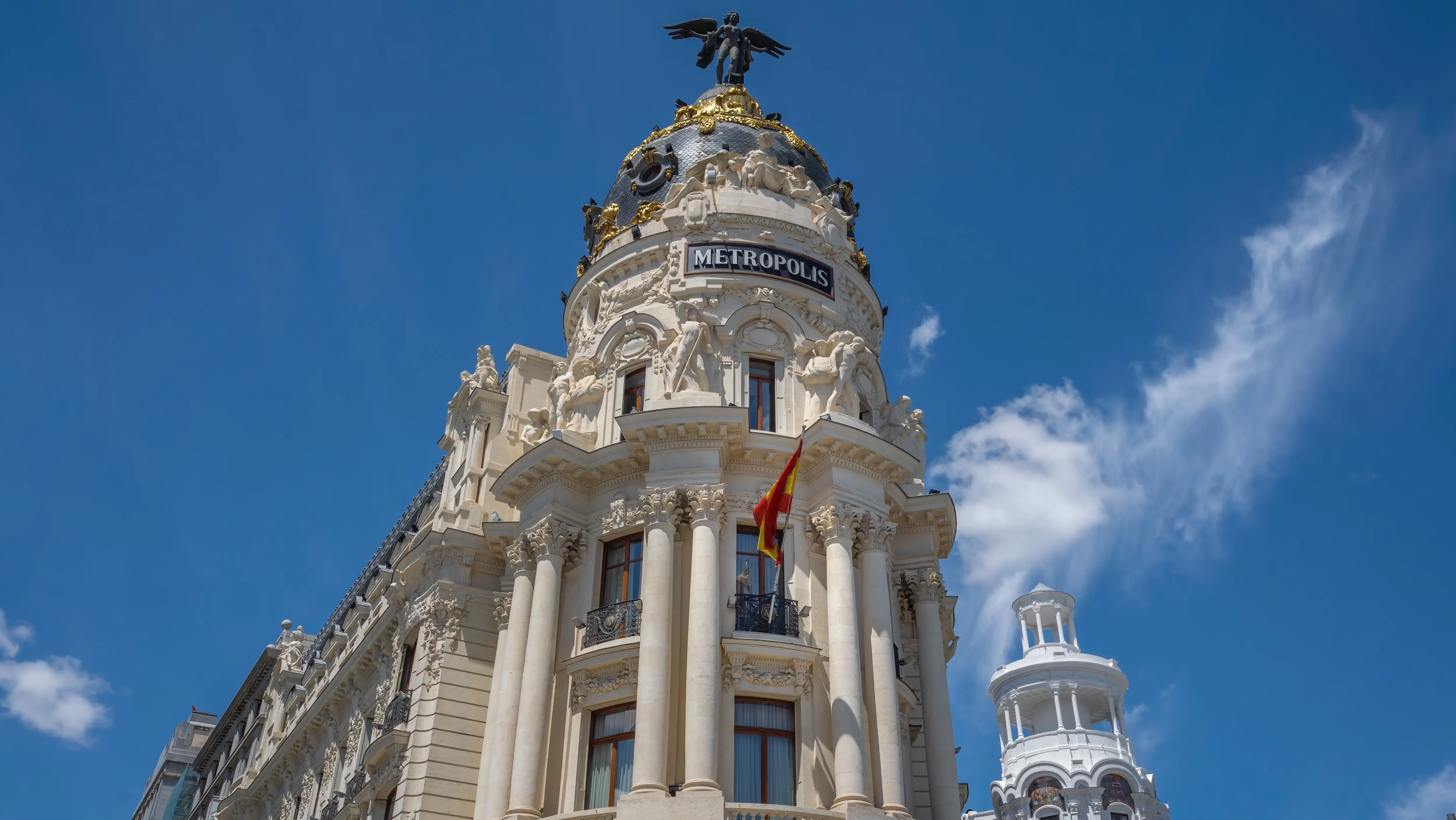 Winged statue and ornate dome of the Edificio Metrópolis, Gran Vía, Madrid, Spain