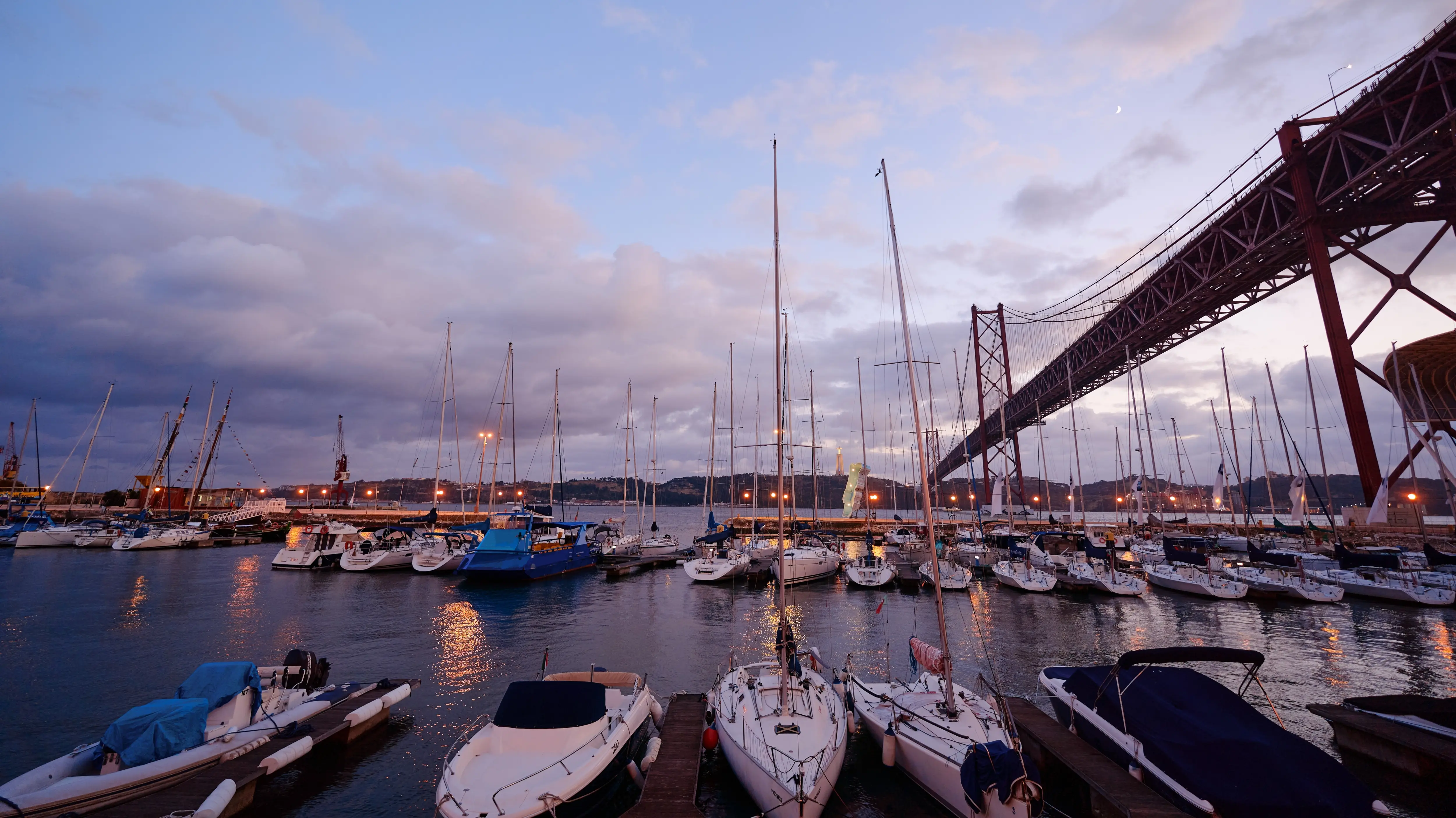 Alcântara docks under the 25 de Abril Bridge (Ponte 25 de Abril) at sunset, Lisbon, Portugal