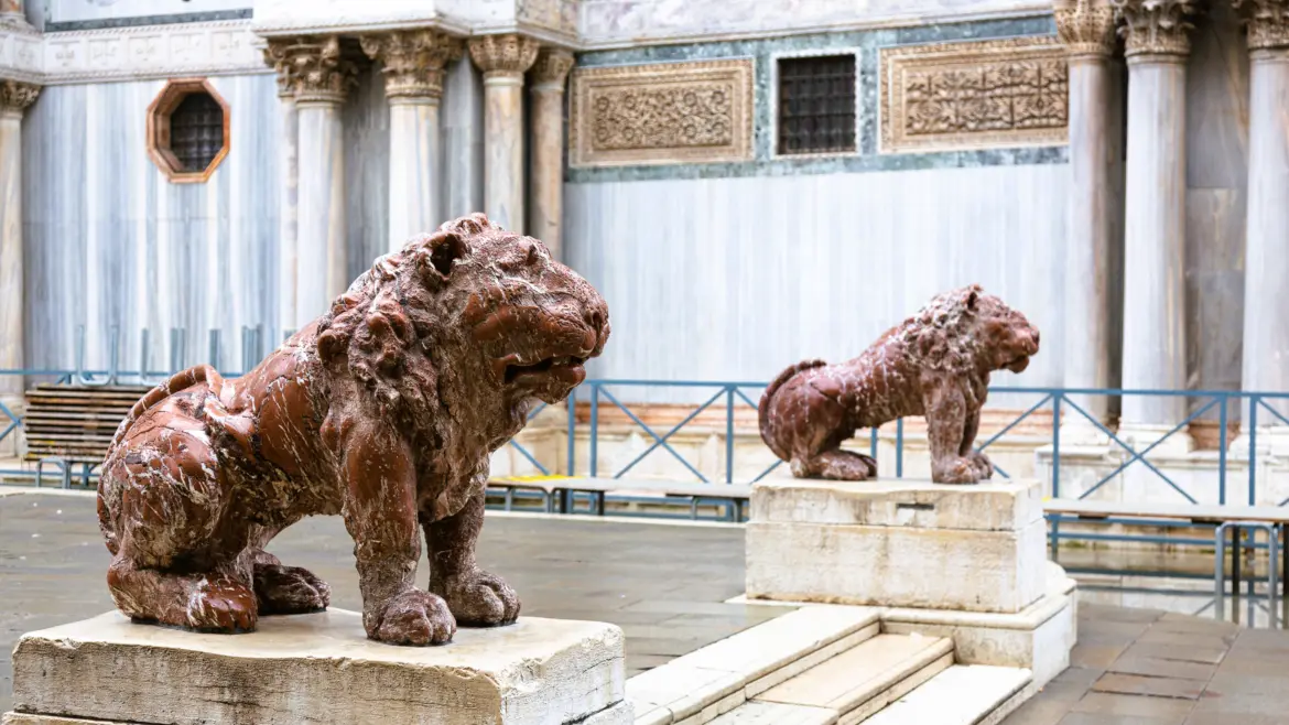 Two brown marble lions sit on staircase St Mark's Square Venice Italy pedestals front St Mark's Basilica