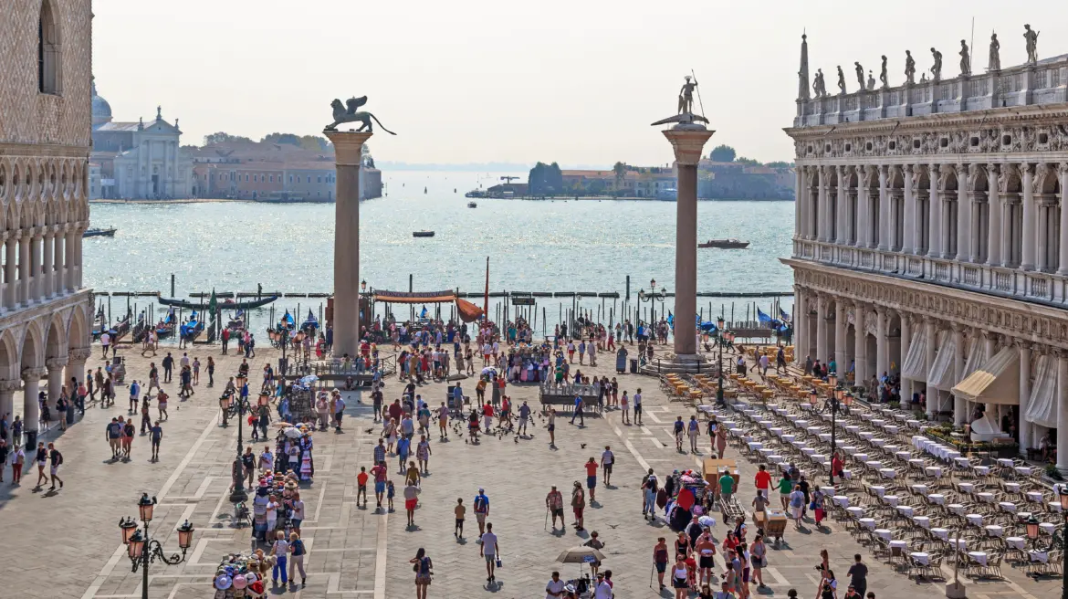 View Columns St Mark and St Theodore Piazzetta San Marco surrounded by visitors overlooking Venetian Lagoon Venice Italy