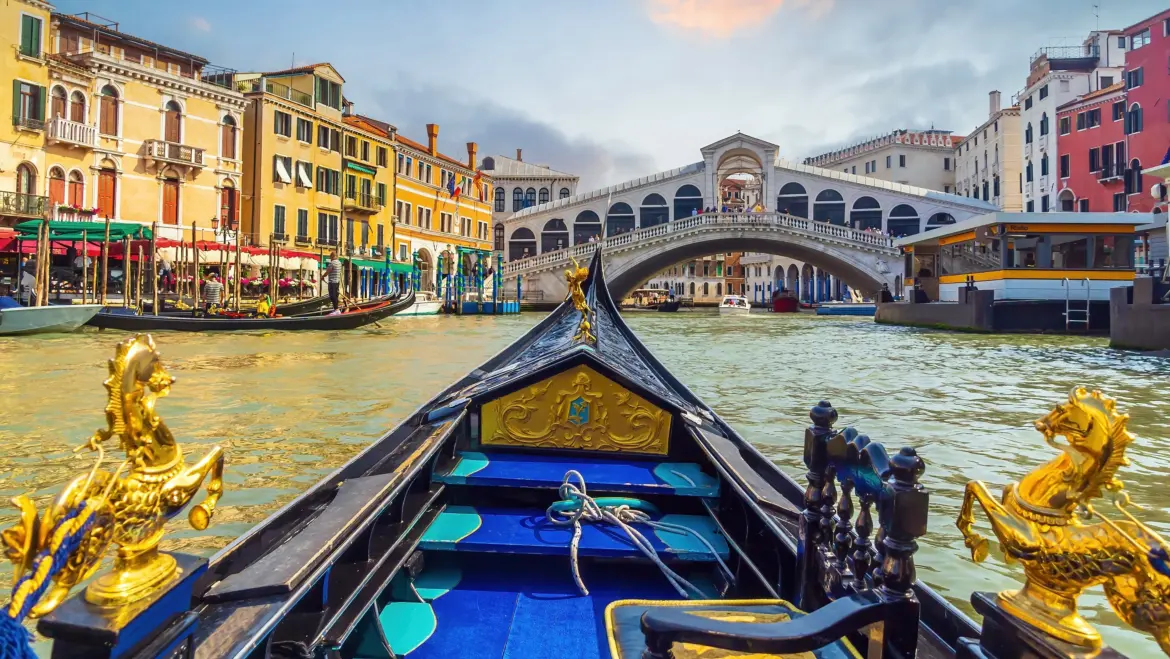 Beautiful interior craftsmanship details Venetian gondola approaching Rialto Bridge Grand Canal Venice