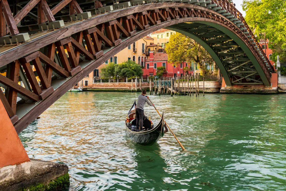 Gondola gliding beneath Ponte dell'Accademia Accademia Bridge passing quietly along Grand Canal Venice Italy