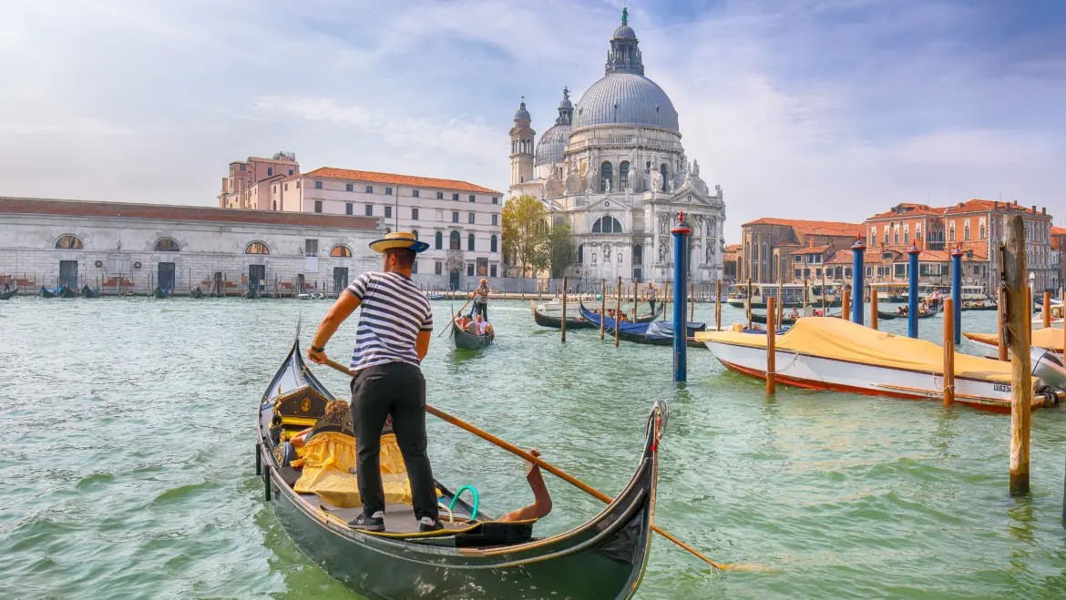 Morning cityscape Venice Grand Canal Santa Maria della Salute gondolier navigating water Venice Italy