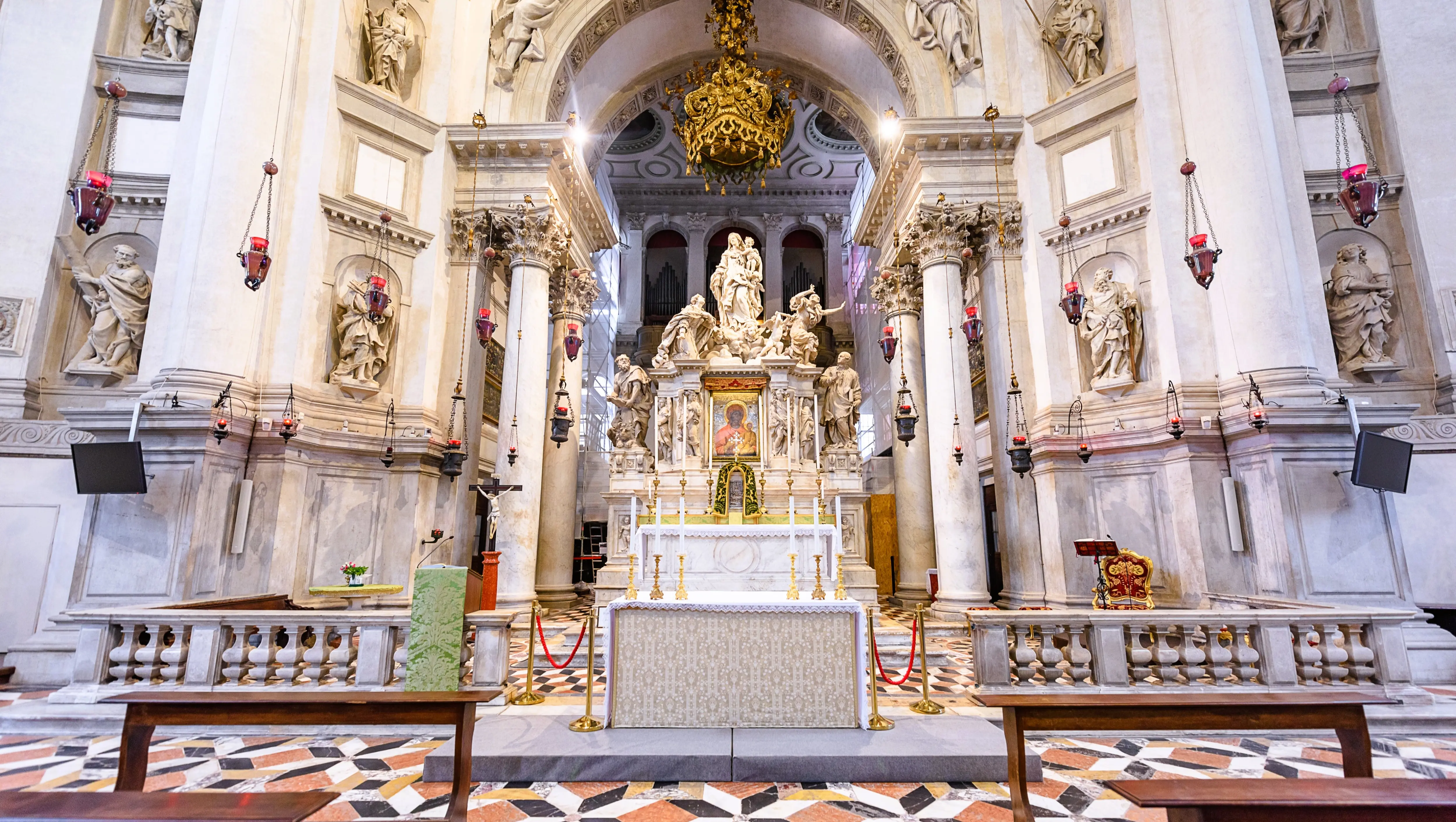High altar sculpture Santa Maria della Salute showing Venice kneeling before Virgin Mary driving away plague Baroque interior Venice Italy