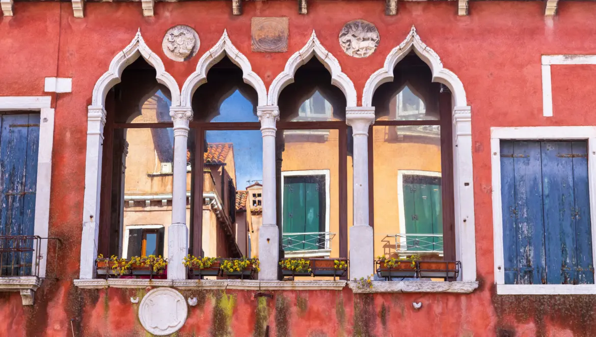 Peaked arched windows slightly worn historic building Castello district Venice Italy time-softened architecture quiet charm authentic residential neighborhoods