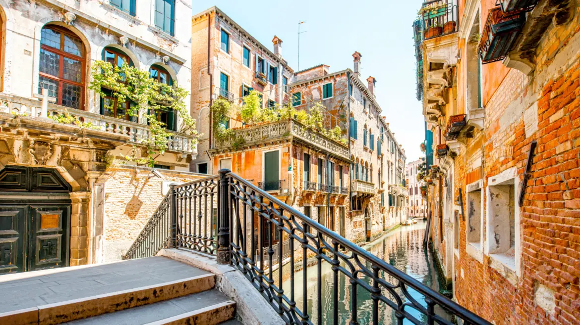 Small romantic canal stone bridge Castello district Venice Italy narrow waterways historic architecture calm residential atmosphere authentic neighborhoods