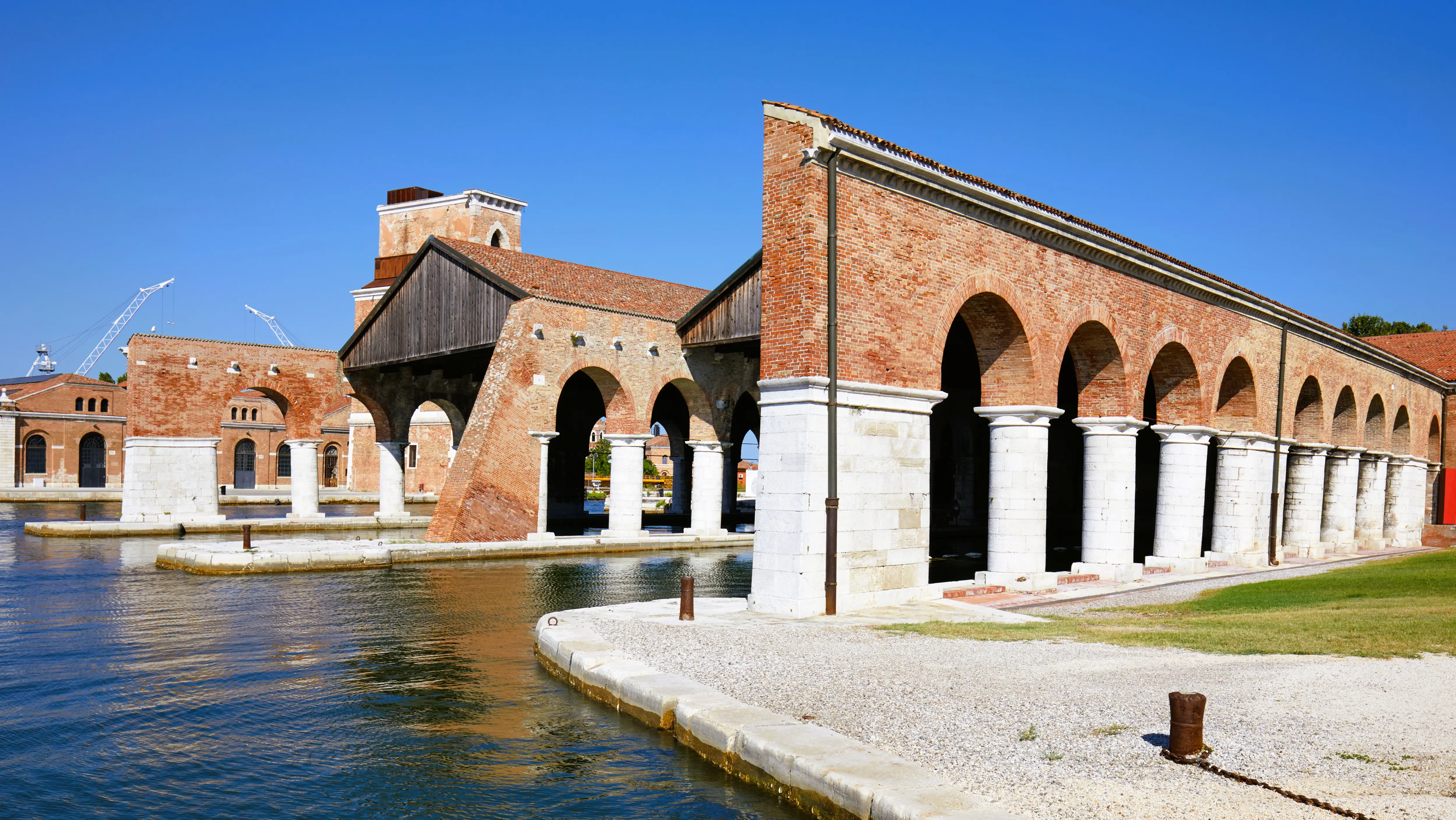 Sunny daytime view Venetian Arsenal Arsenale di Venezia showing historic docks arched arcade along canal Castello district Venice Italy