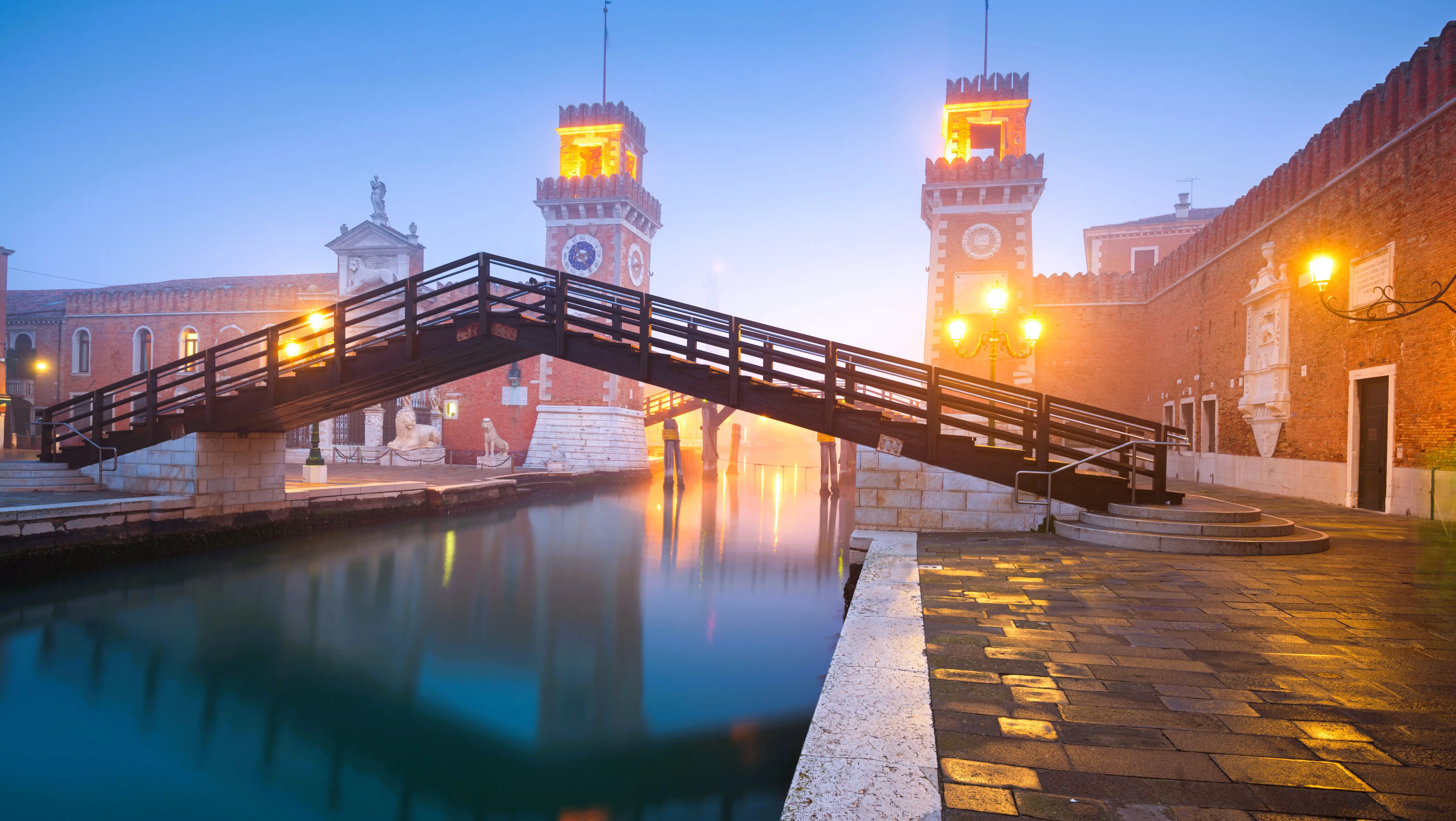 Early morning view Venetian Arsenal Arsenale di Venezia emerging through light fog Venice Italy historic brick towers canals quiet atmospheric monumental presence