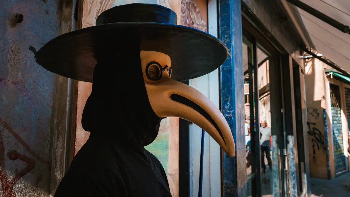 Traditional Venetian plague doctor mask with long beak worn on Venice street evoking 1630 Black Death pandemic historical significance