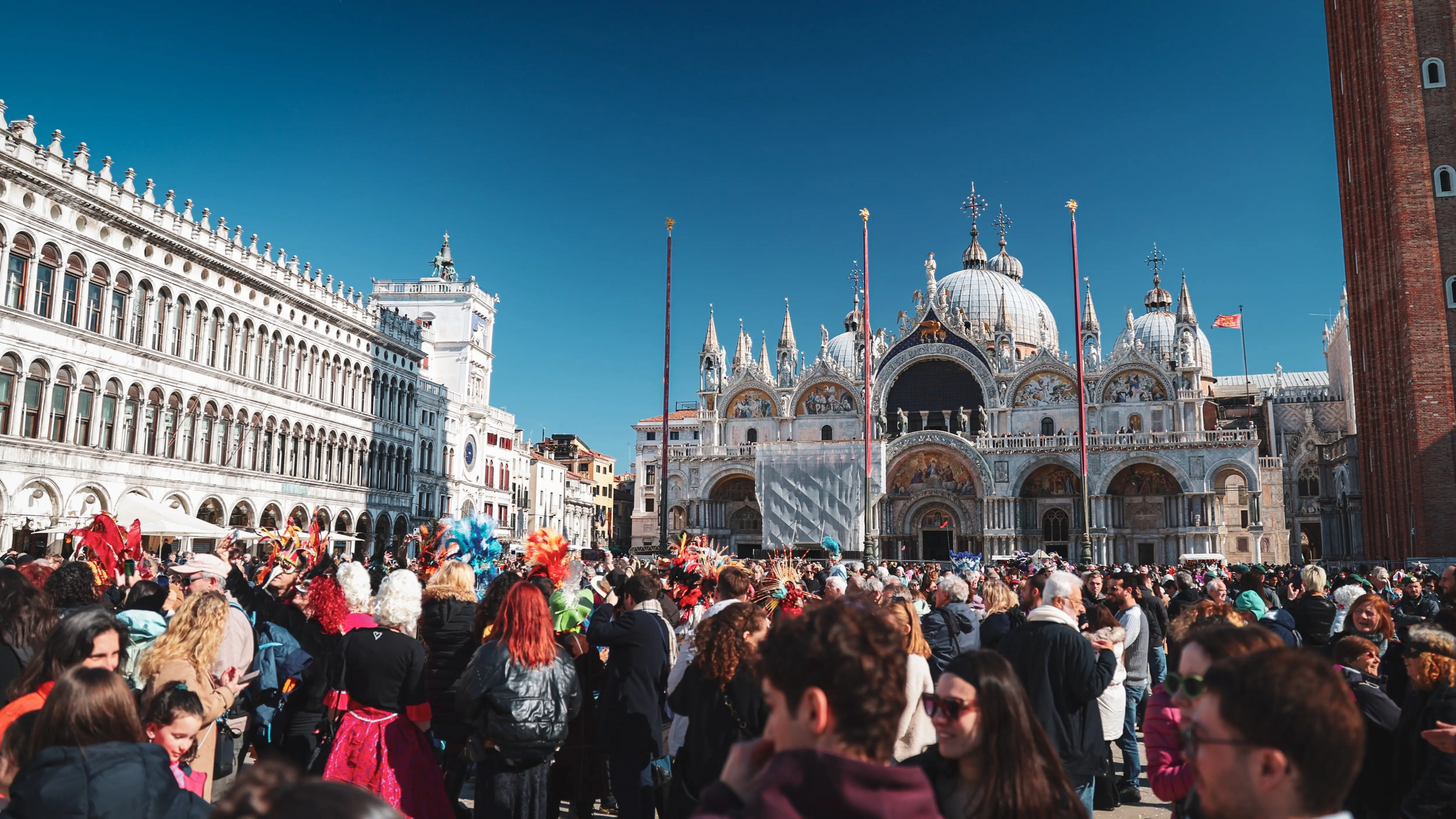 Packed Piazza San Marco during Venice Carnival crowds gathered historic landmarks celebrate Carnevale di Venezia Venice Italy festive energy elaborate costumes iconic setting
