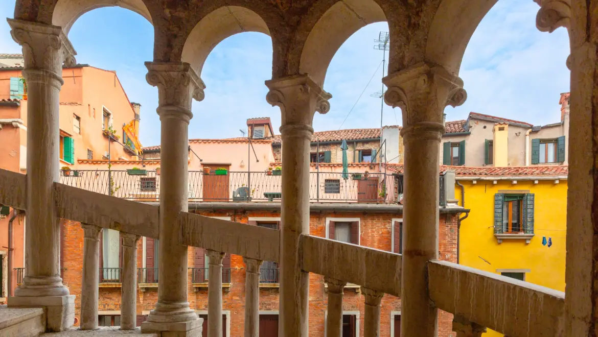 View from spiral staircase Scala Contarini del Bovolo overlooking historic Venetian rooftops Venice Italy