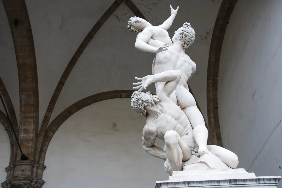 Giambologna marble sculpture Abduction of the Sabine Women at the Loggia dei Lanzi in Florence showing three spiraling figures beneath Gothic vaulted ceiling