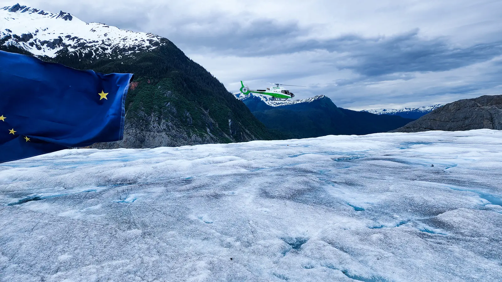 The Alaska state flag displayed on the surface of the Mendenhall Glacier during a TEMSCO tour in Juneau