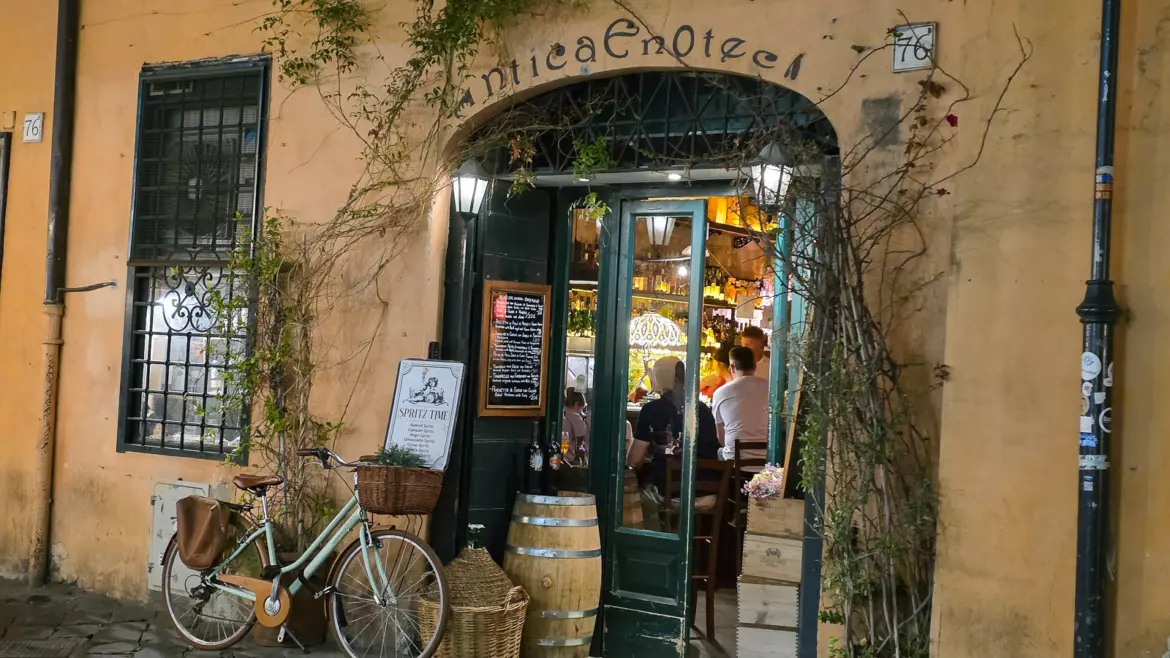 Antica Enoteca Ristorante wine bar in Rome at night with warm glowing interior bicycle parked outside and ivy-covered entrance