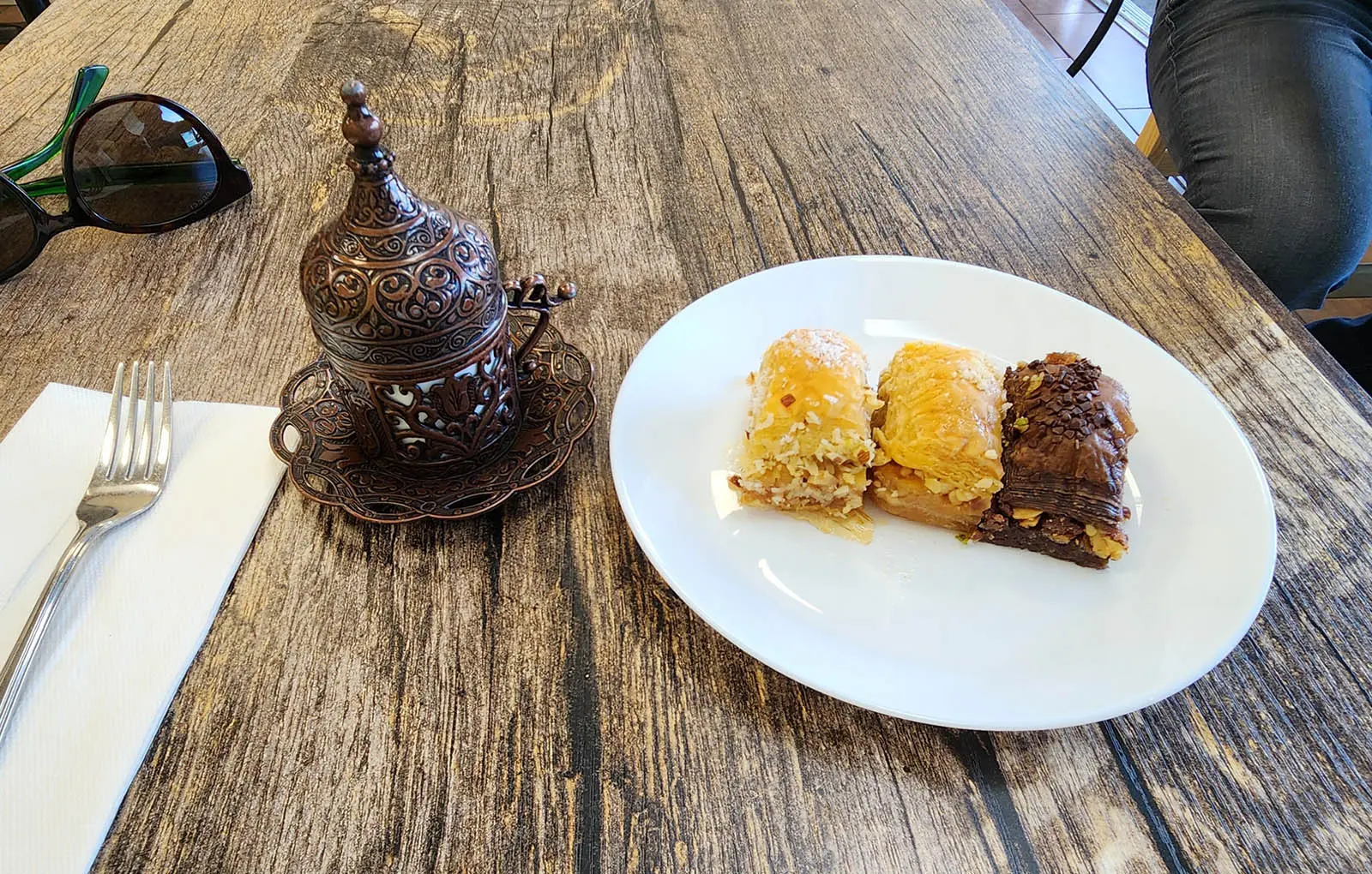 Assortment of baklava and traditional Turkish coffee in ornate copper cup at The Golden Horn Turkish Bakery Canada Place Vancouver