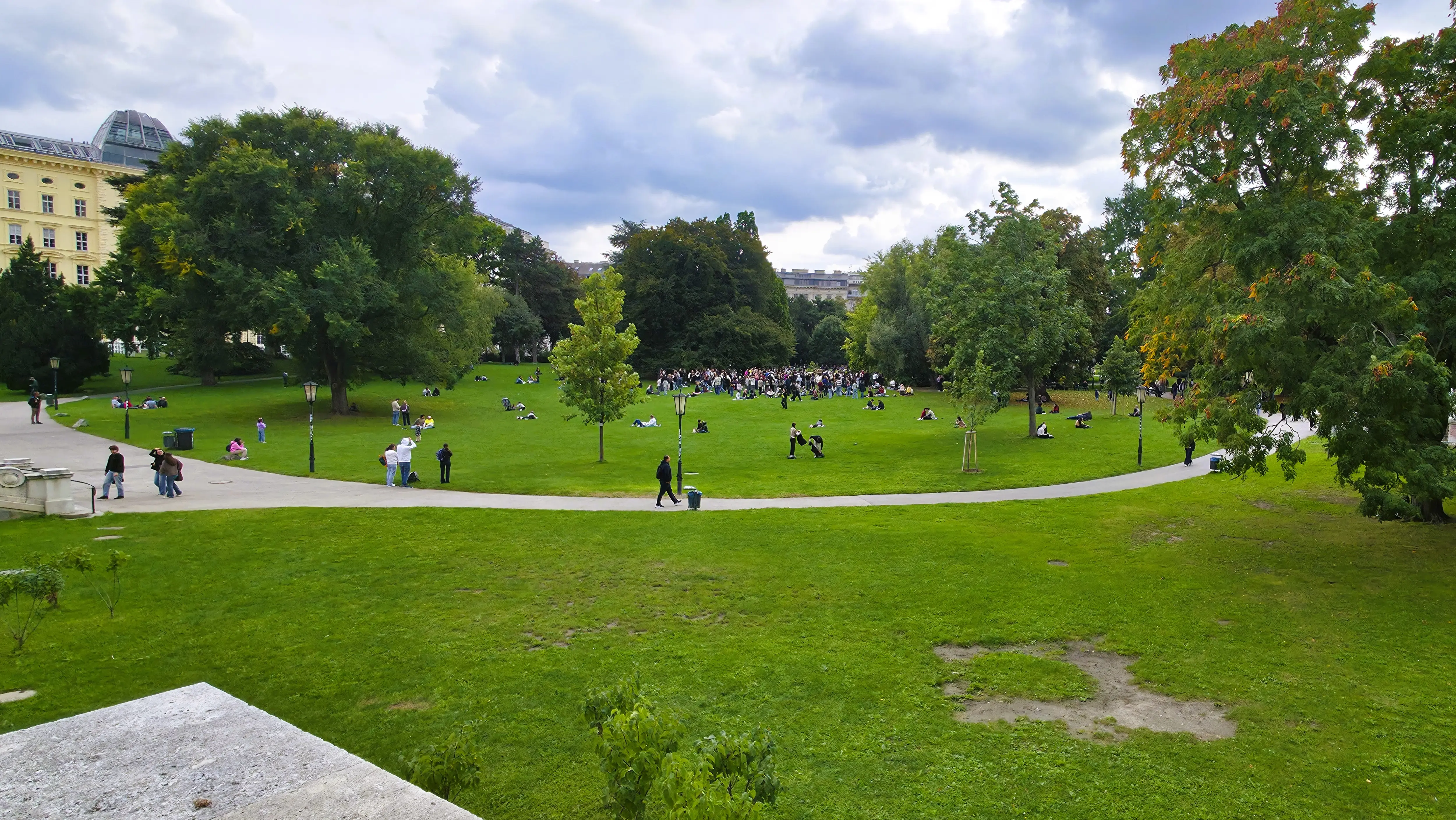 People gathered and relaxing on the green spaces of Burggarten in Vienna