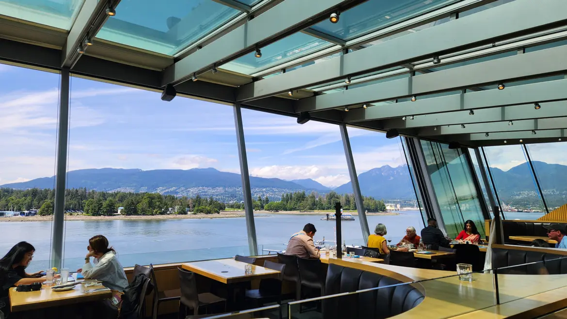 The outdoor patio at Cactus Club Cafe Coal Harbour with views of the mountains, water, and Stanley Park