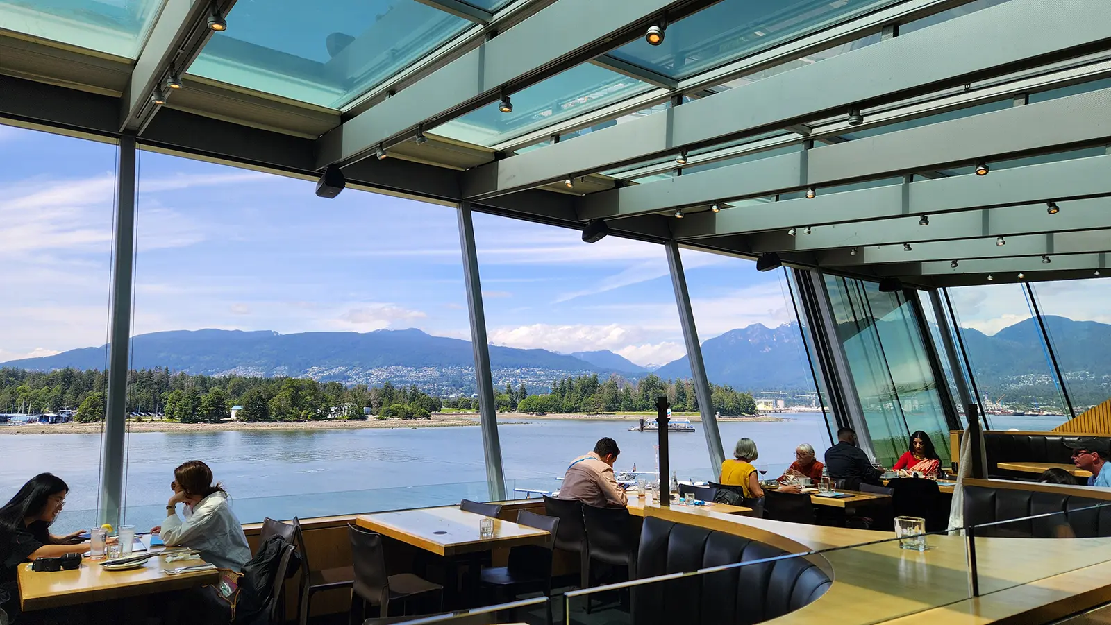 The outdoor patio at Cactus Club Cafe Coal Harbour with views of the mountains, water, and Stanley Park