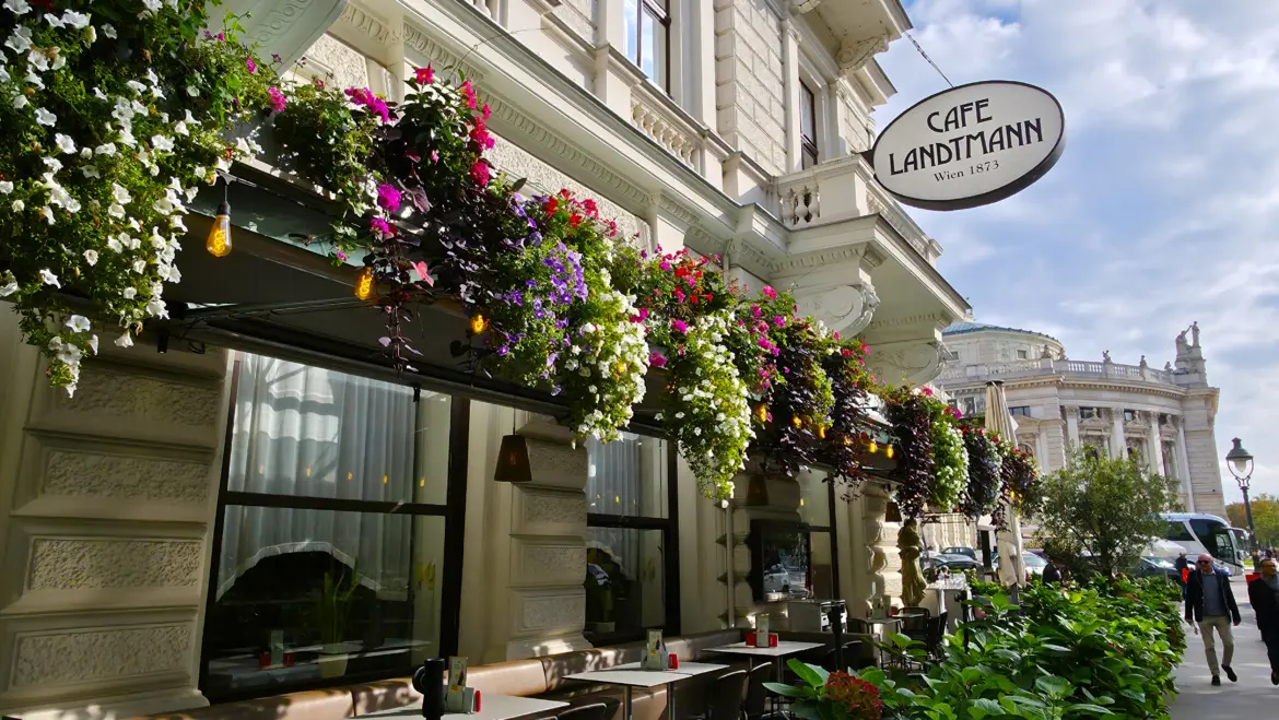 The outdoor terrace of Café Landtmann on Vienna’s Ringstrasse, shaded by trees with views of the city’s cultural landmarks