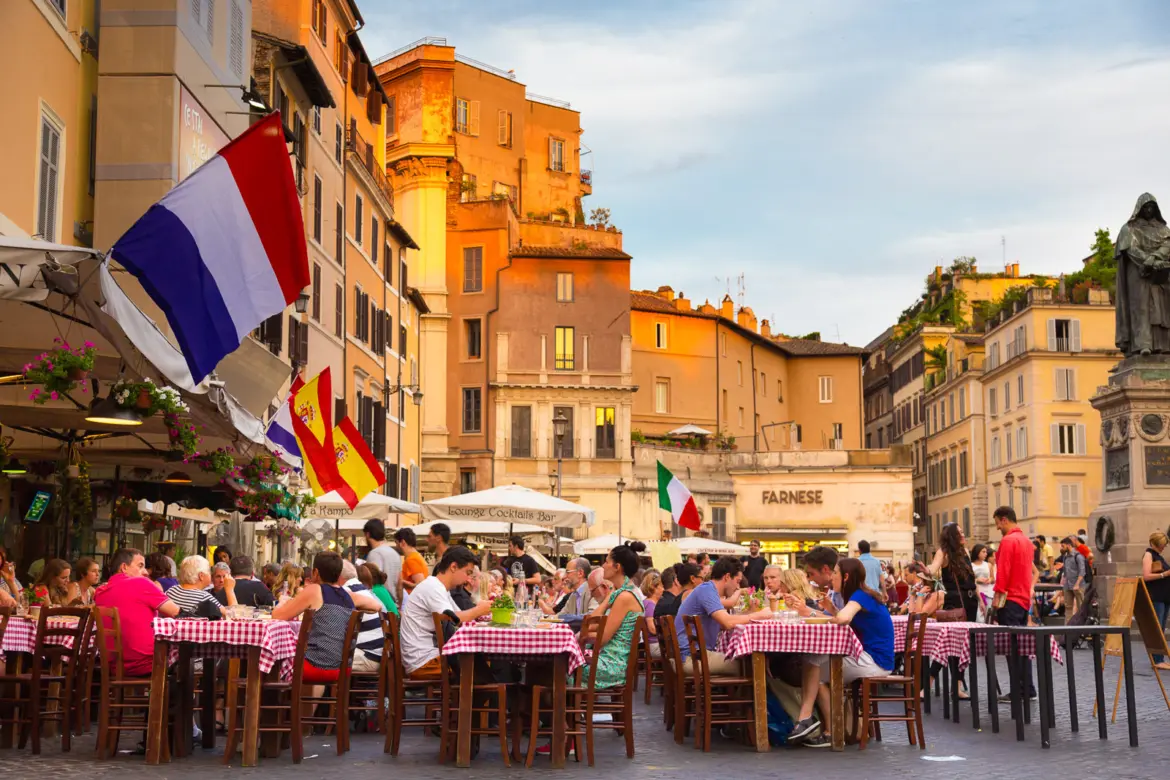 Campo de Fiori in Rome at evening with warm light market stalls giving way to outdoor dining and nightlife