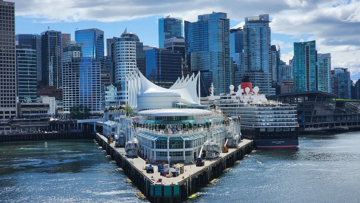 Canada Place cruise ship terminal in Vancouver Harbour with cruise ships docked and the city skyline behind