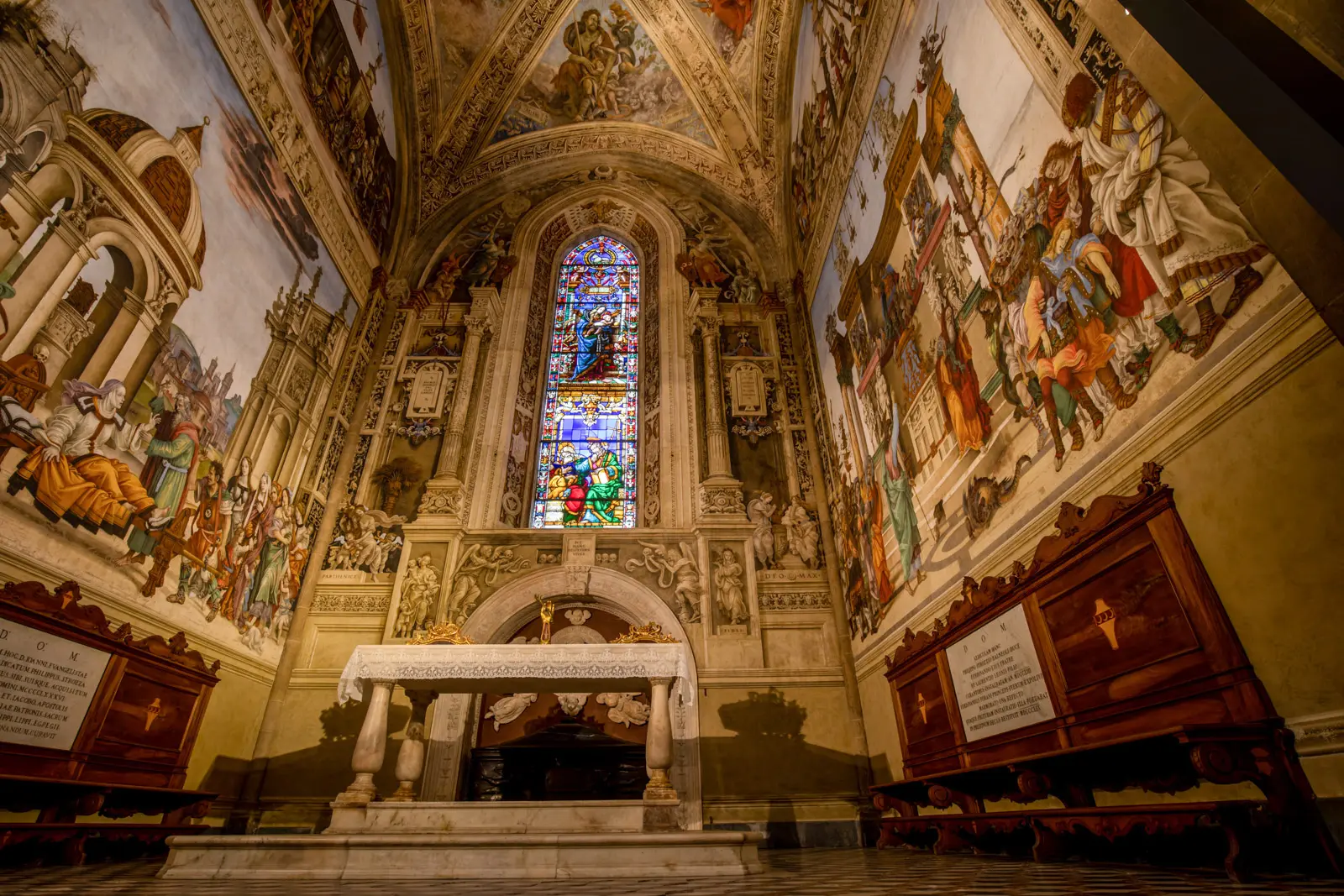 The Filippo Strozzi Chapel inside Santa Maria Novella in Florence, featuring frescoes by Filippino Lippi depicting the lives of Apostle Philip and Saint James the Great, with stained glass window and marble altar