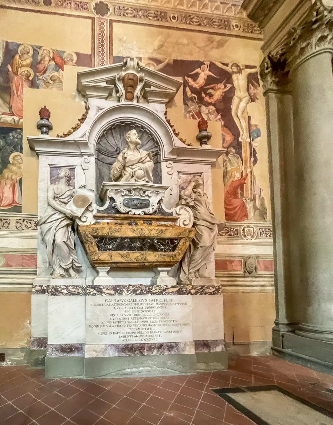 Tomb of Galileo Galilei inside Santa Croce Basilica in Florence with sculptural figures and frescoes surrounding the monument