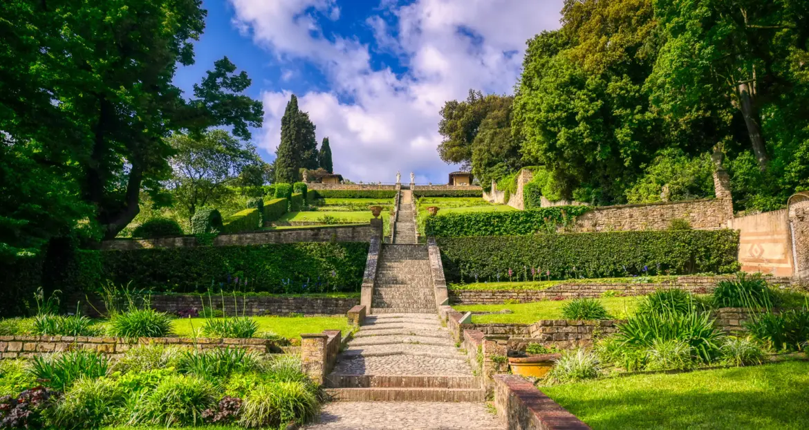 The dramatic central staircase of Giardino Bardini in Florence flanked by manicured greenery rising through terraced gardens toward the sky