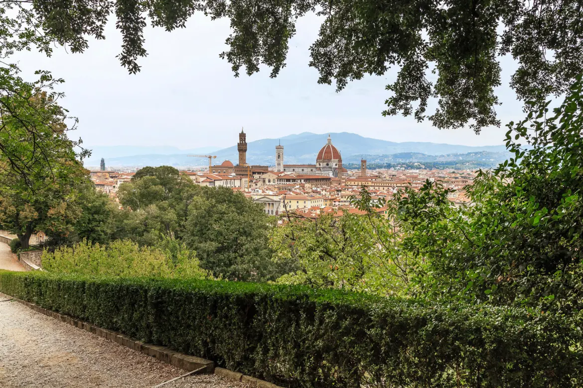 Panoramic view of Florence from Giardino Bardini showing the Duomo dome and Giotto Bell Tower rising above rooftops framed by garden trees