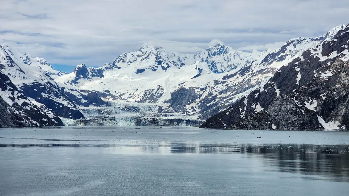 Panoramic view of Glacier Bay National Park showing glaciers, mountains, and calm waters in Alaska