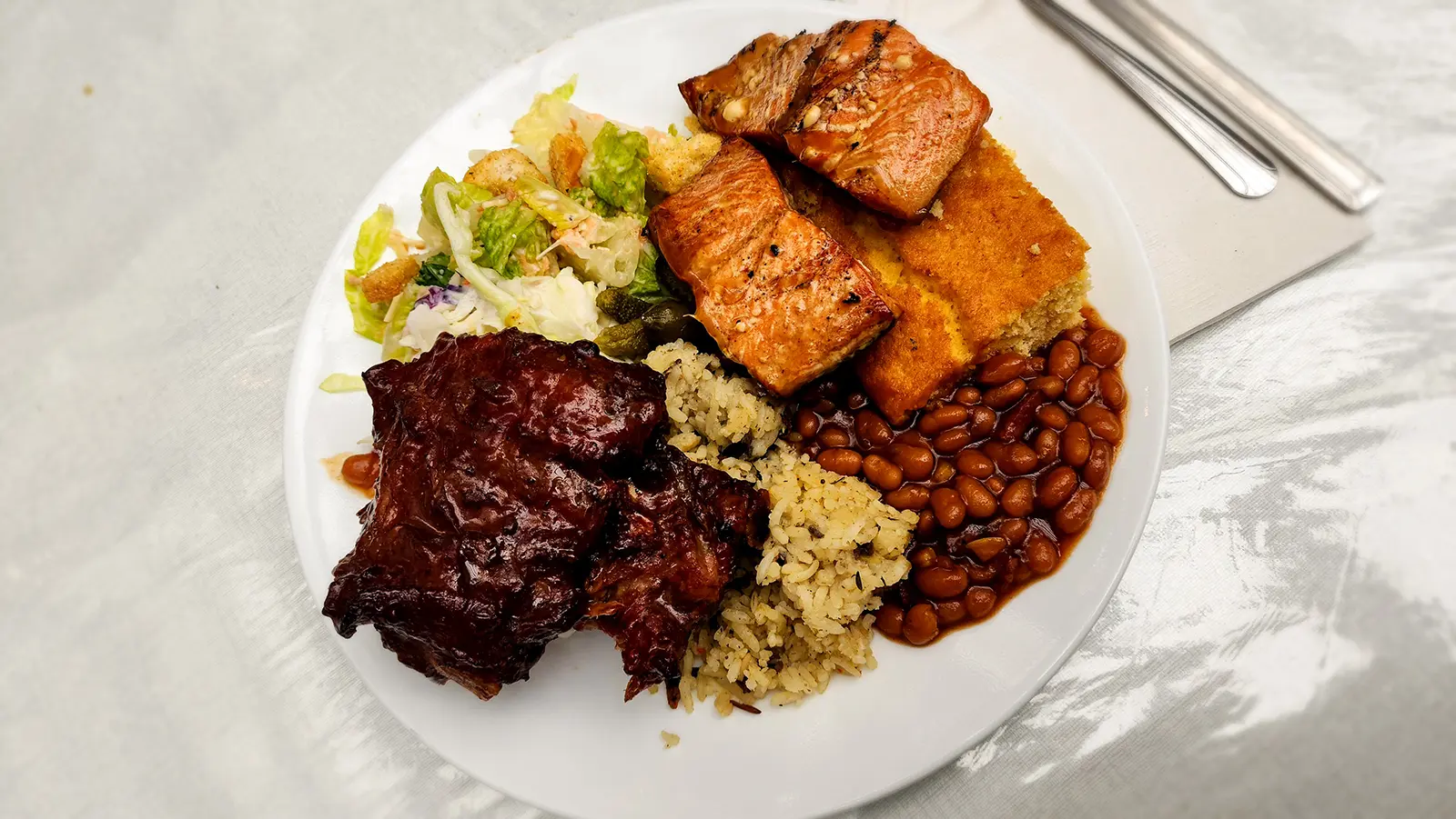 A plate of grilled Alaskan salmon, ribs, baked beans, and sides from the Gold Creek Salmon Bake in Juneau