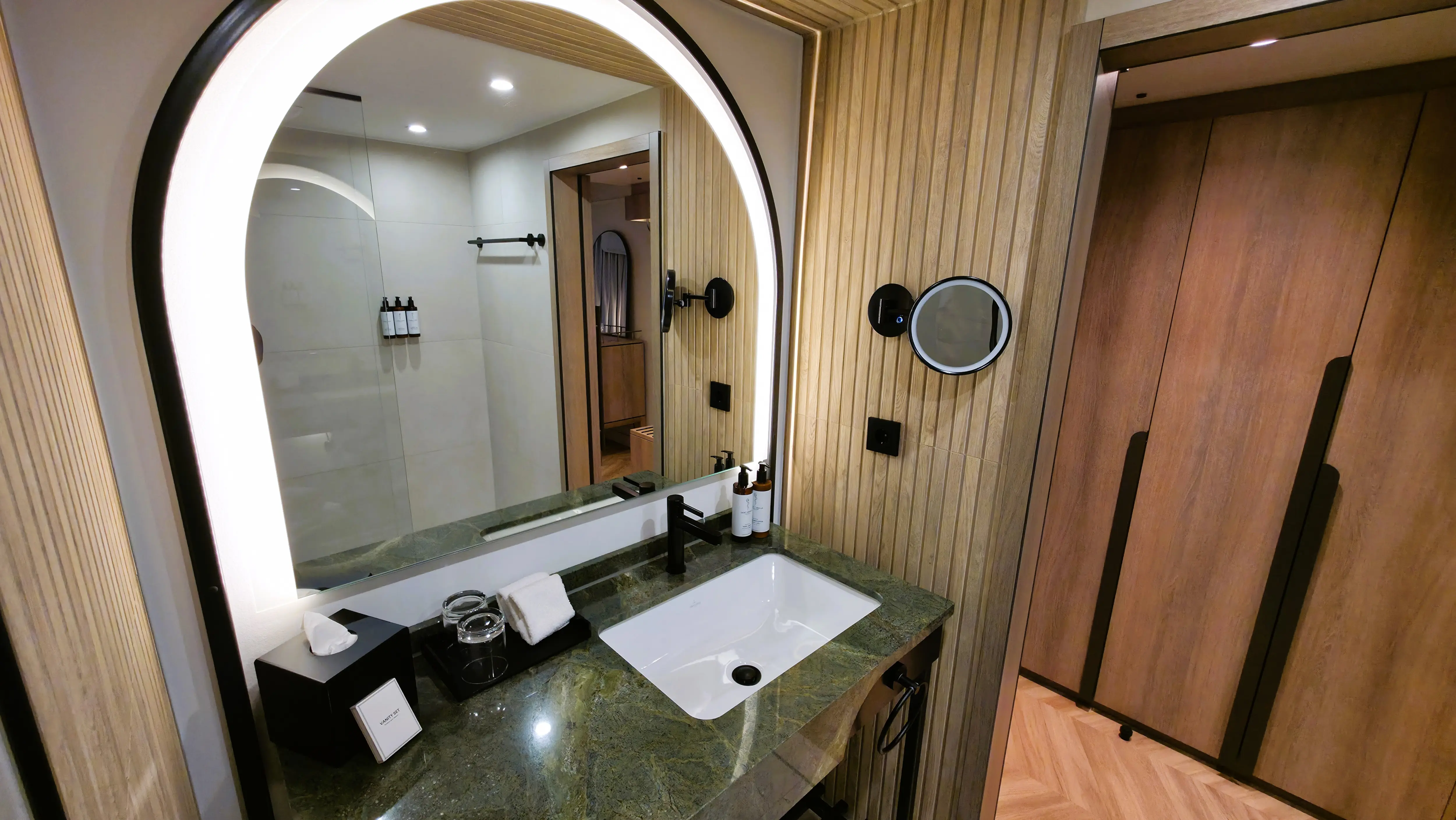 The green marble bathroom in the Deluxe King Room at the Imperial Riding School in Vienna, featuring Saint Charles Apothecary amenities