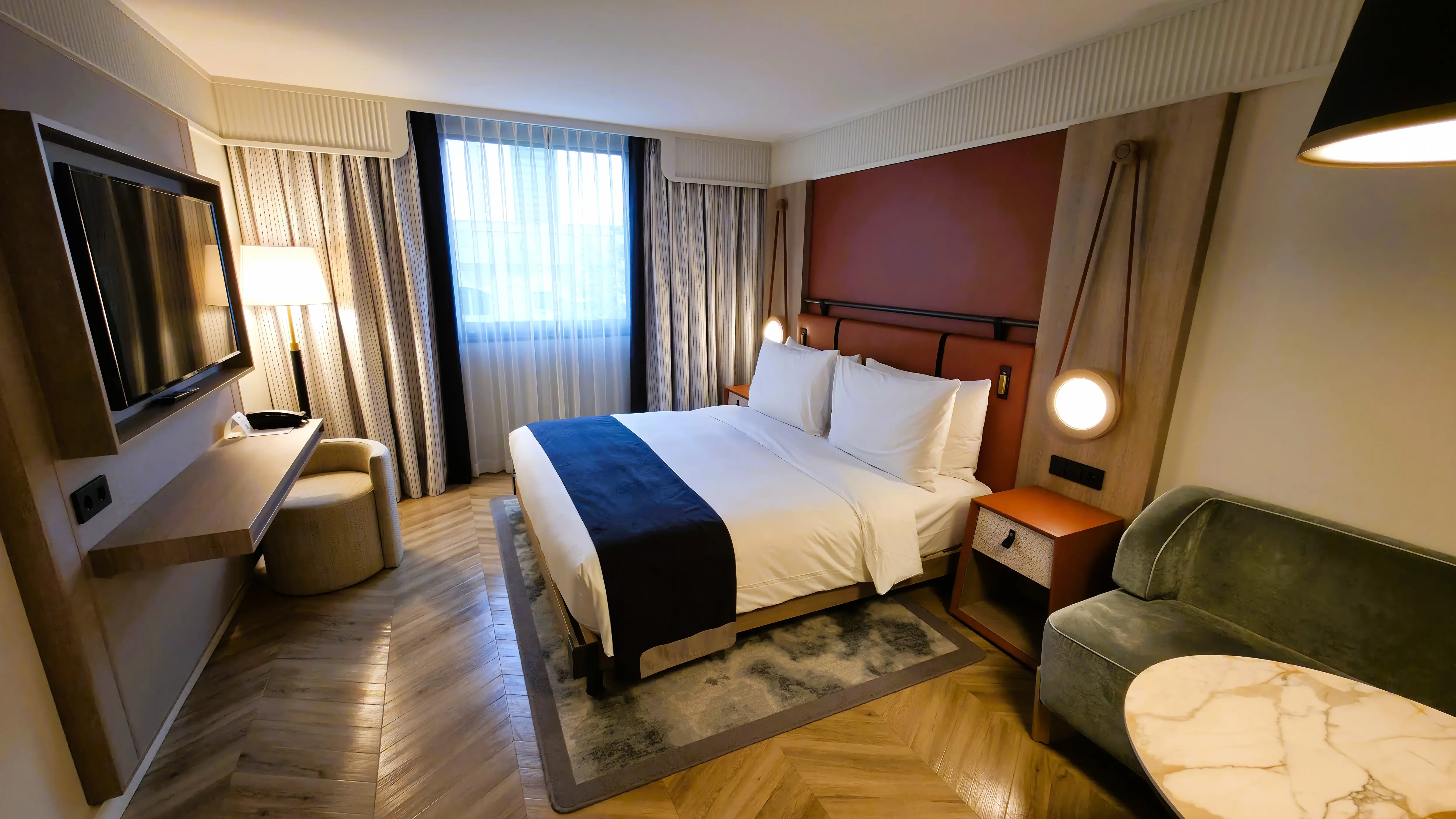 The Deluxe King Room at the Imperial Riding School, Autograph Collection in Vienna, featuring a comfortable king bed with warm textures and contemporary design