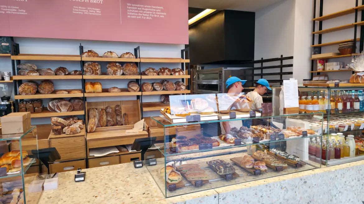Bakers working inside Joseph Brot in Vienna surrounded by freshly baked organic bread