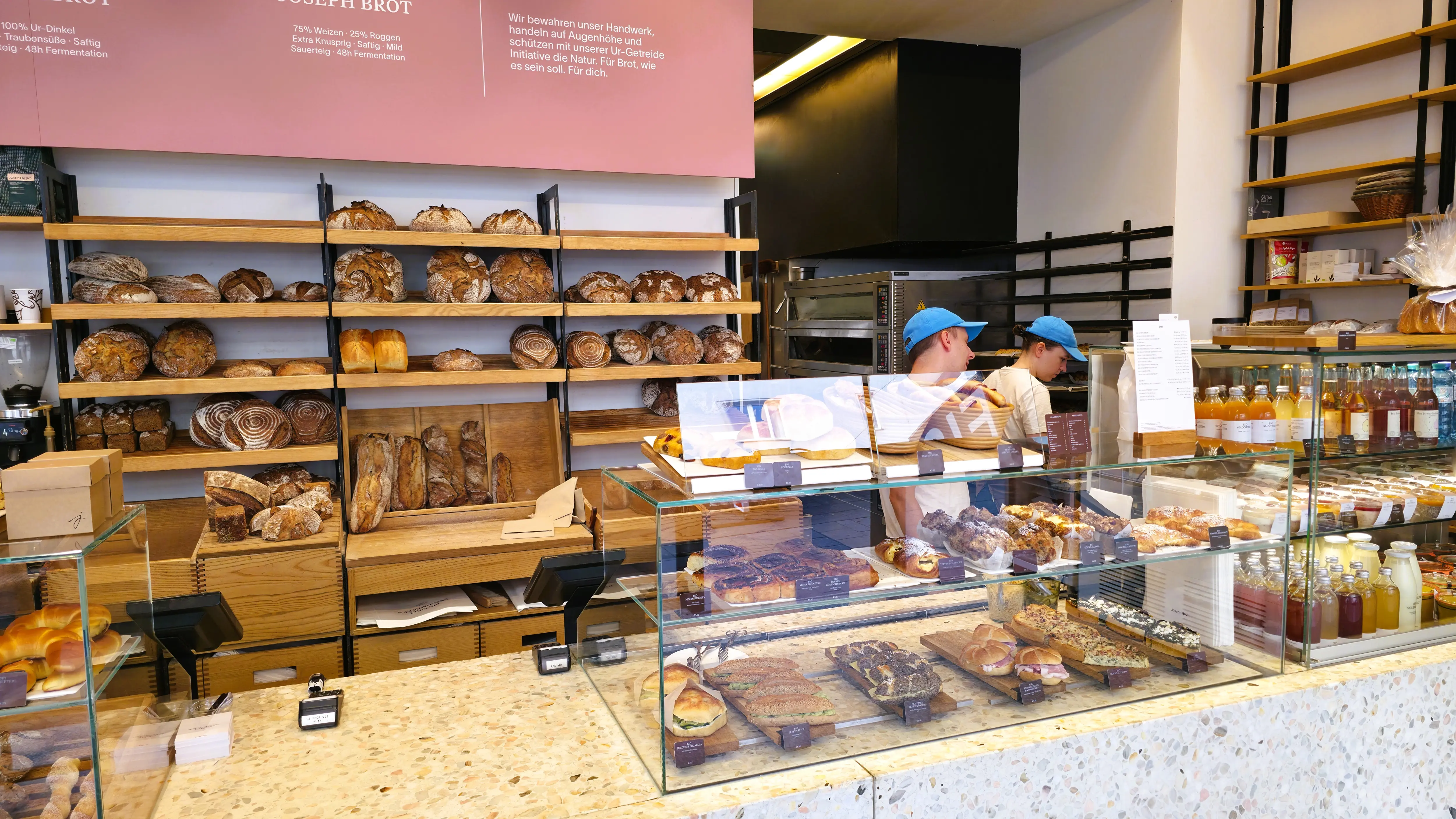 Bakers working inside Joseph Brot in Vienna surrounded by freshly baked organic bread