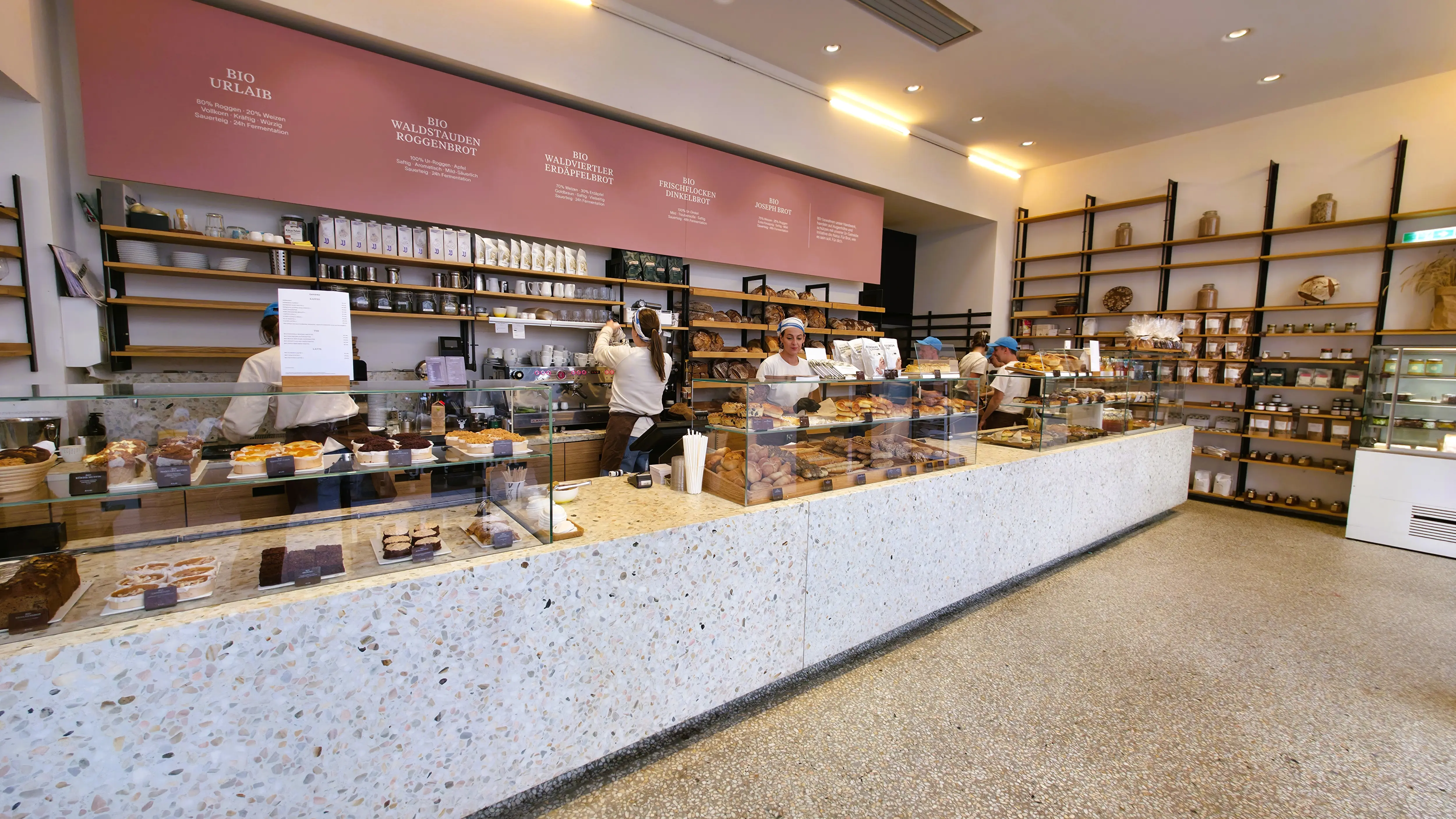 The warm, modern interior of Joseph Brot in Vienna featuring wood tones and open bread displays