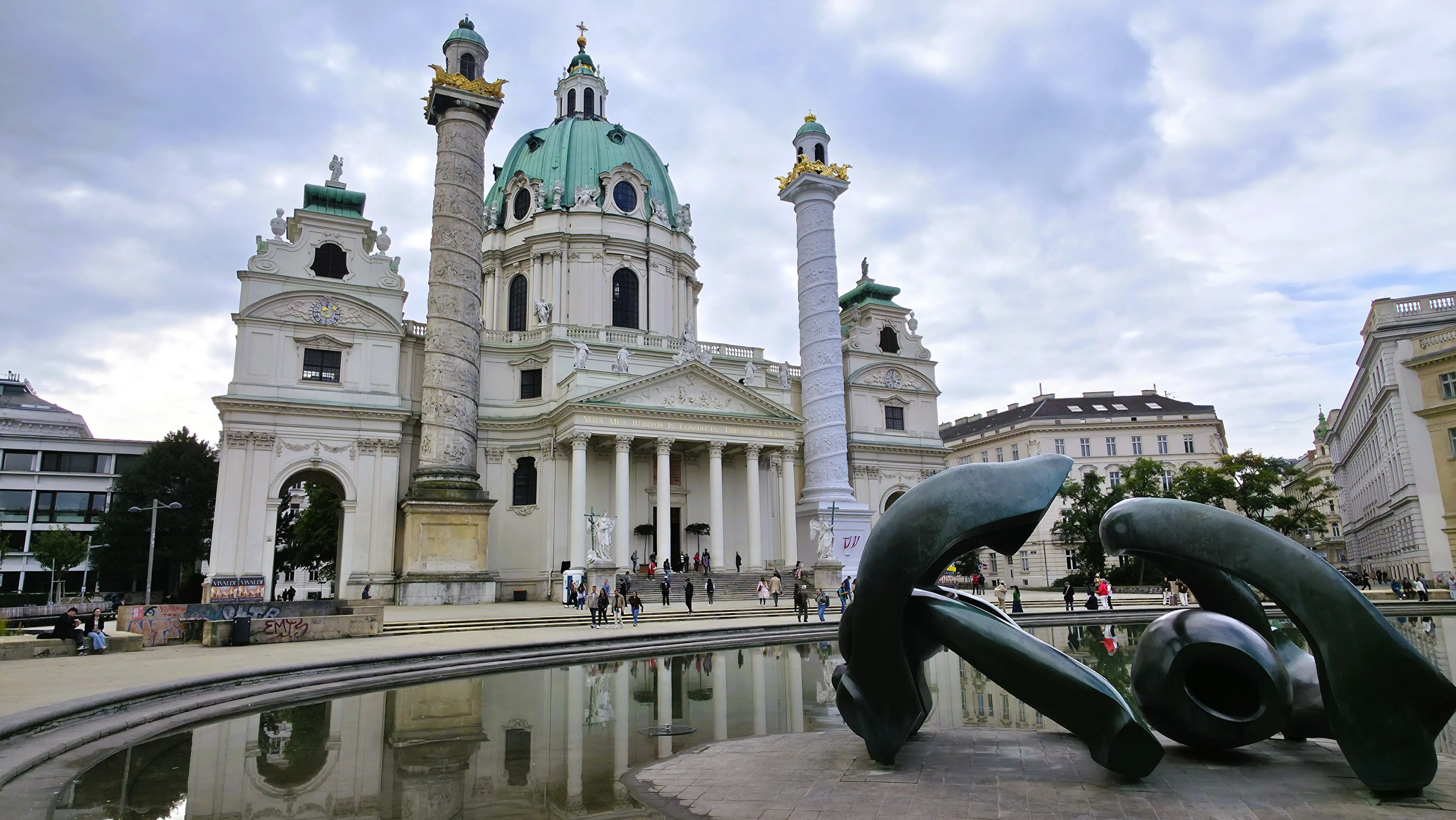 Karlskirche reflected in the shallow pool at Karlsplatz in Vienna, Austria, with its Baroque dome and twin columns mirrored in the water