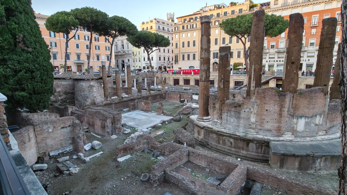 Largo di Torre Argentina sunken archaeological site in Rome showing ancient temple ruins columns and umbrella pines with the city above