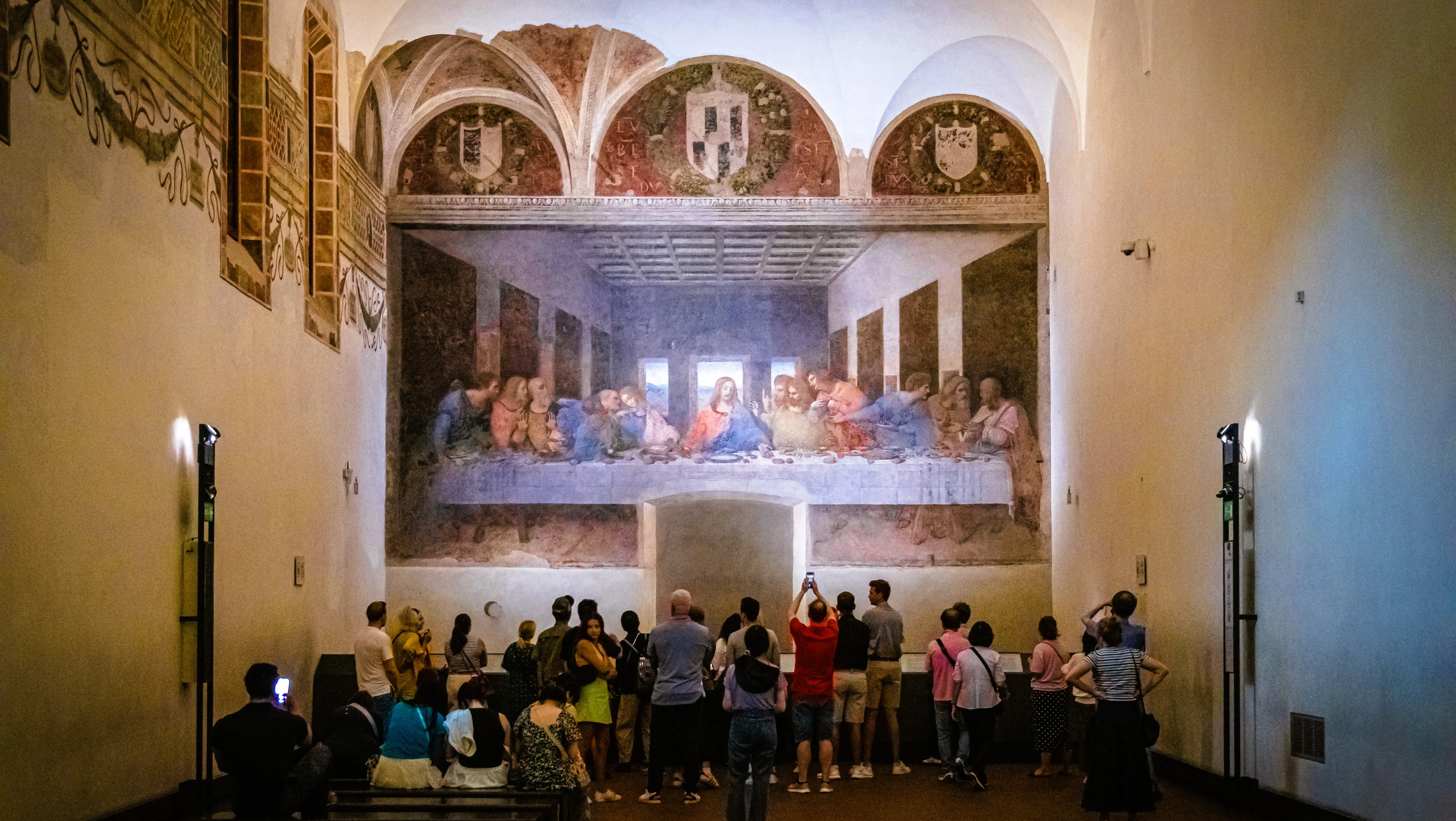 Visitors viewing The Last Supper by Leonardo da Vinci at Santa Maria delle Grazie in Milan, Italy