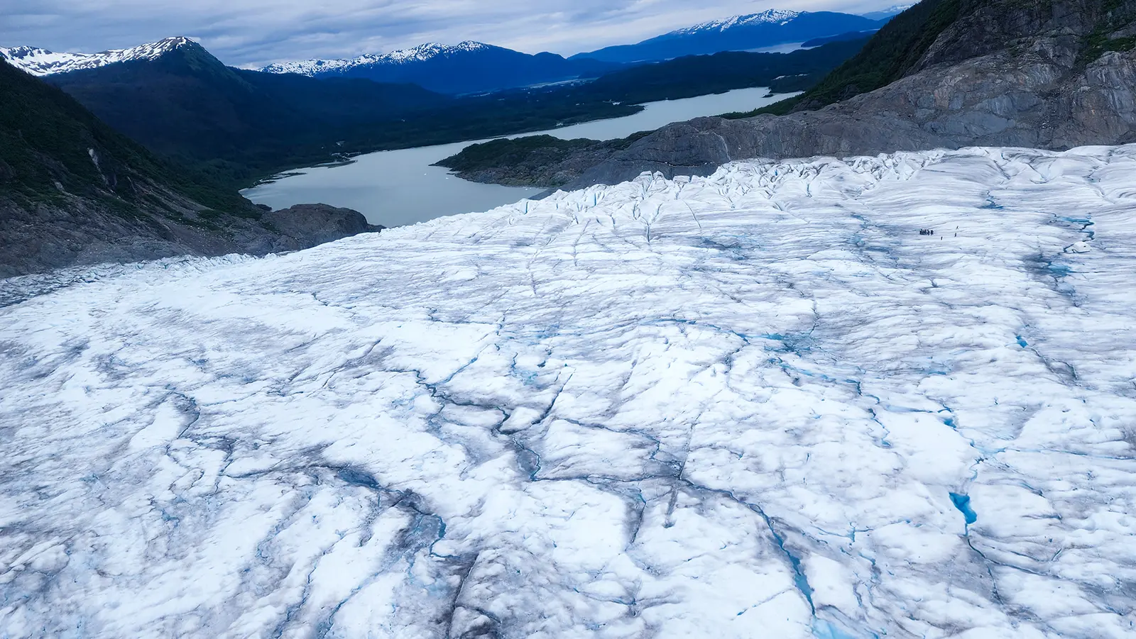 The surface of the Mendenhall Glacier showing crevasses and Mendenhall Lake in the background, Juneau, Alaska