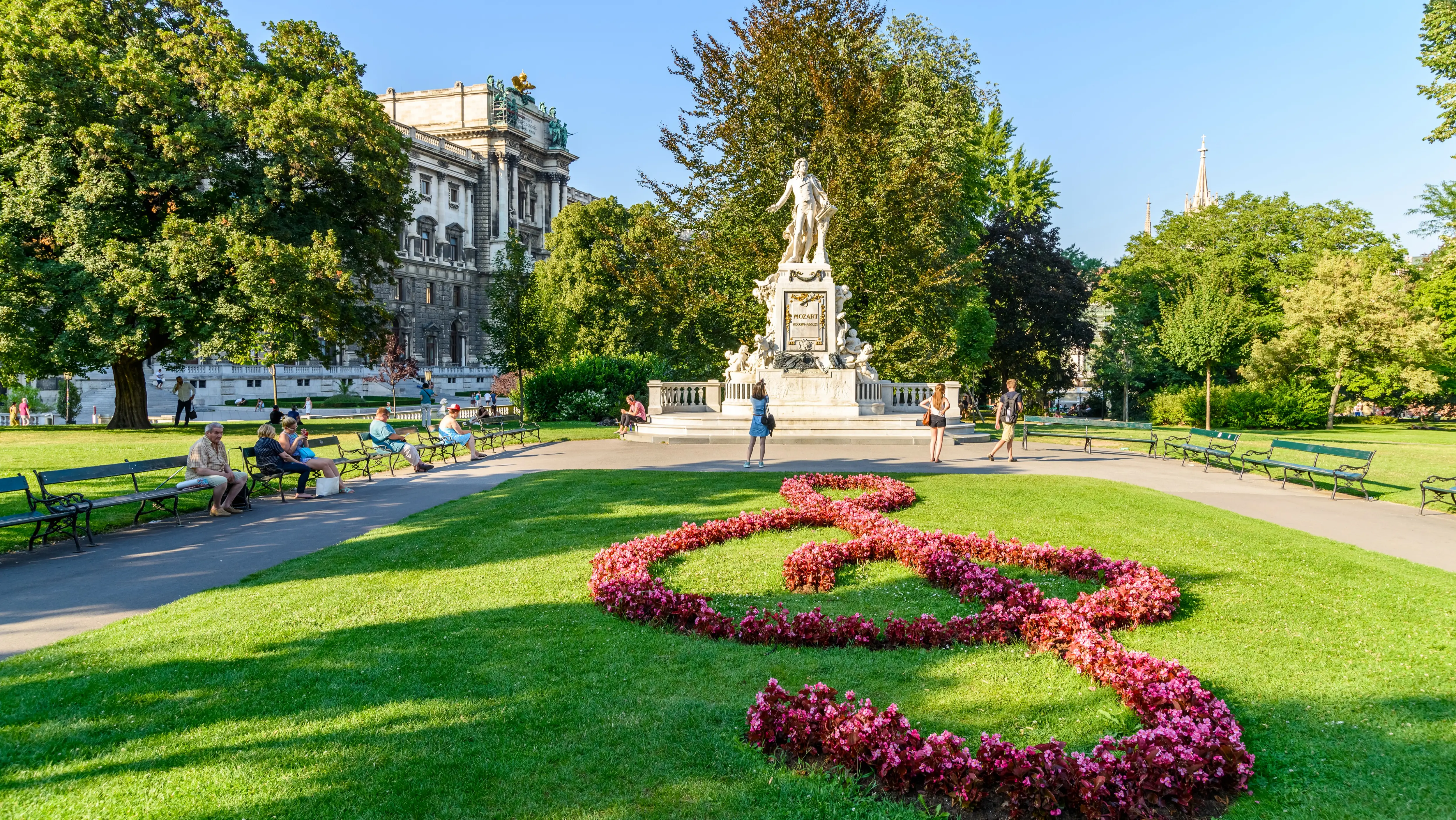 The Mozart statue in Burggarten, Vienna, framed by a floral arrangement shaped as a musical treble clef
