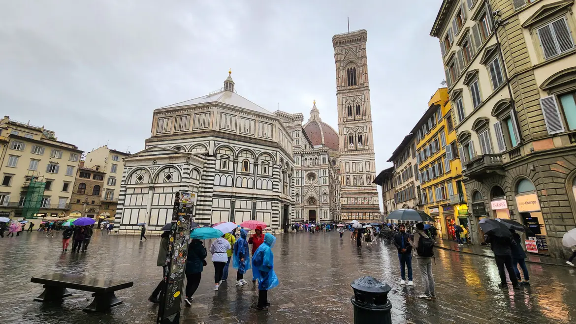 Rainy day in Piazza del Duomo Florence where wet stone streets and soft light create a peaceful atmosphere around the Cathedral Baptistery and Giotto’s Bell Tower
