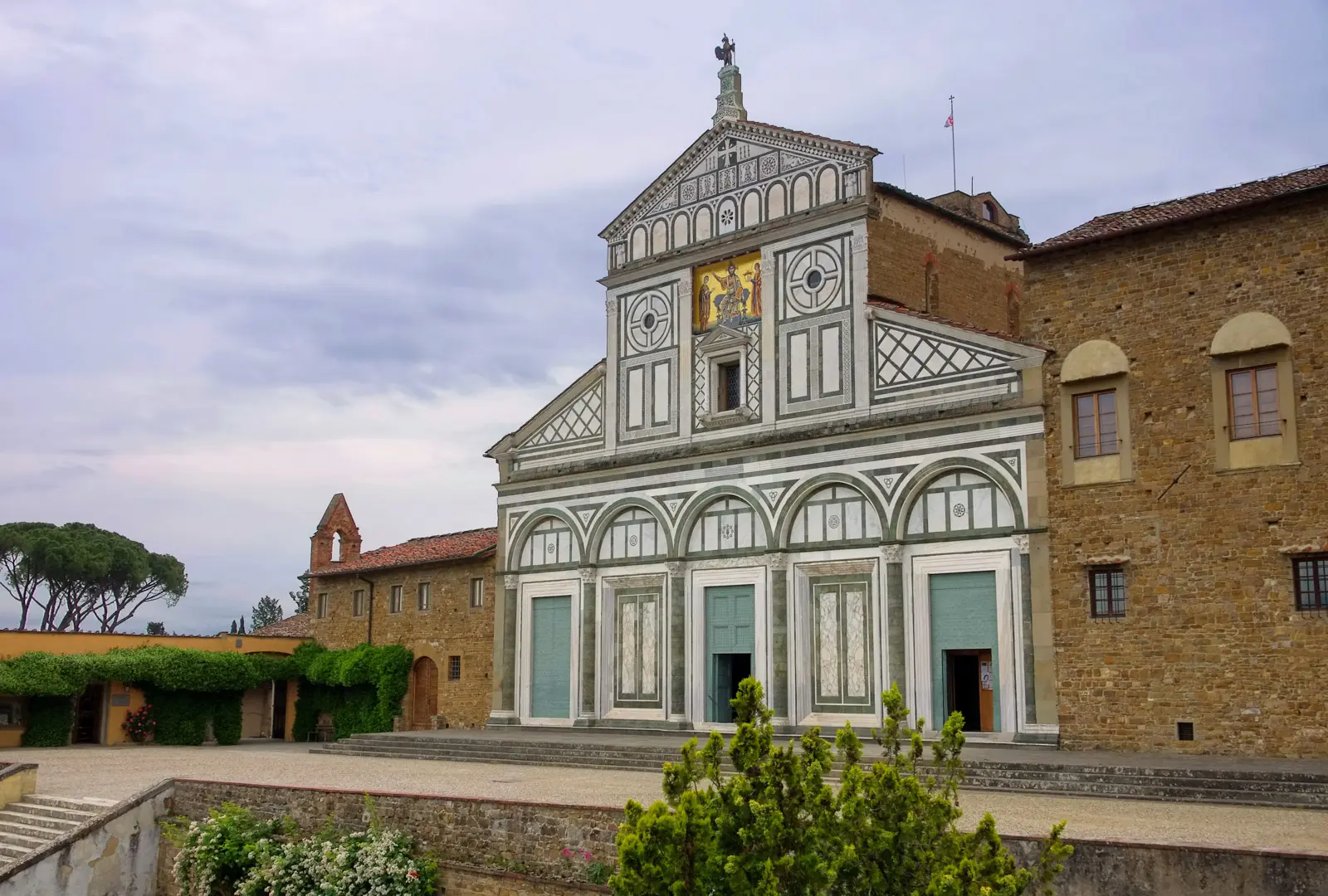 San Miniato al Monte in Florence seen from the open terrace, with the full Romanesque façade in white Carrara and green Prato marble and the city spread below