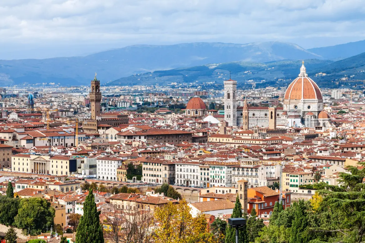 Panoramic view of Florence from the terrace of San Miniato al Monte, with the Duomo, Palazzo Vecchio tower, and terracotta rooftops stretching across the historic center