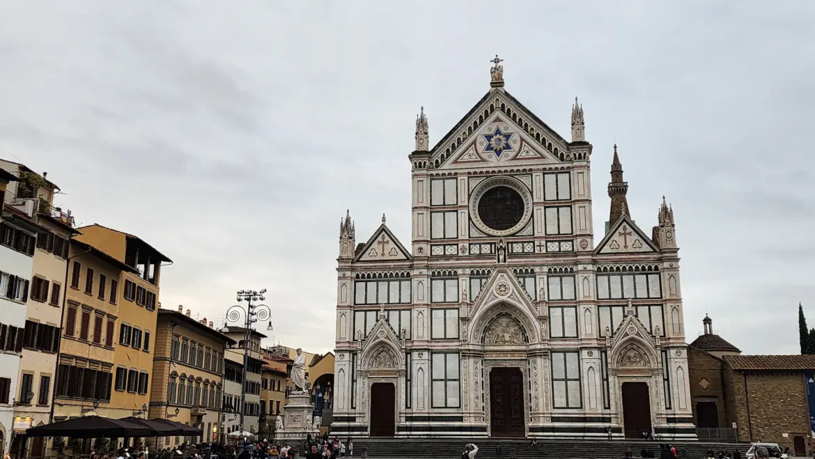 The Neo-Gothic marble facade of Santa Croce Basilica in Florence viewed from Piazza Santa Croce under overcast sky showing white green and pink marble details
