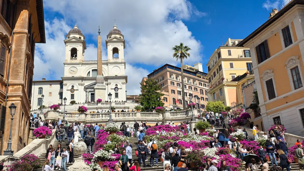 The Spanish Steps in Rome Italy with pink azalea flowers in bloom Trinita dei Monti church at the top and visitors enjoying the spring atmosphere