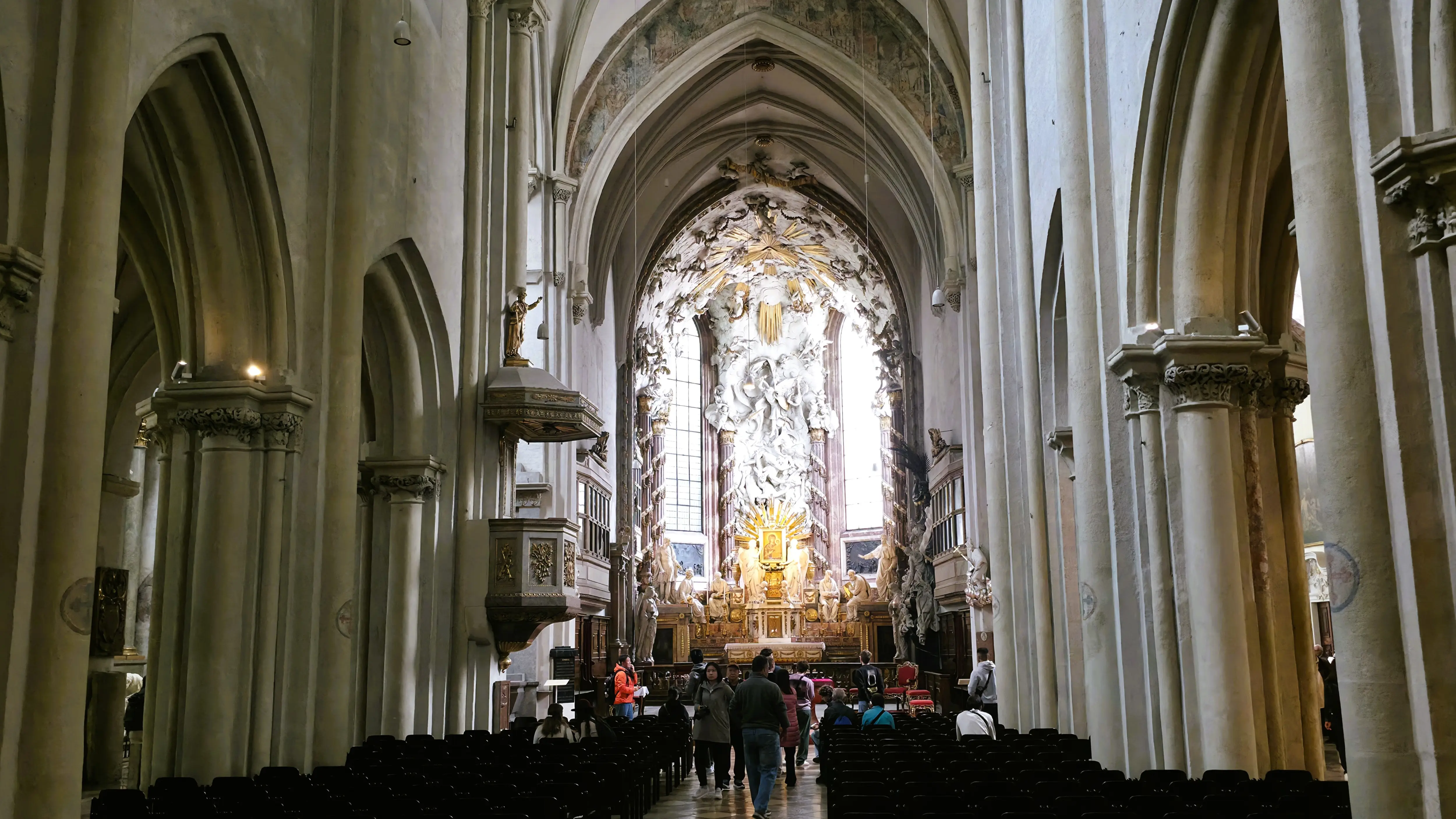 Interior of St. Michael’s Church in Vienna with vaulted ceilings, Gothic columns, and the high altar in the distance