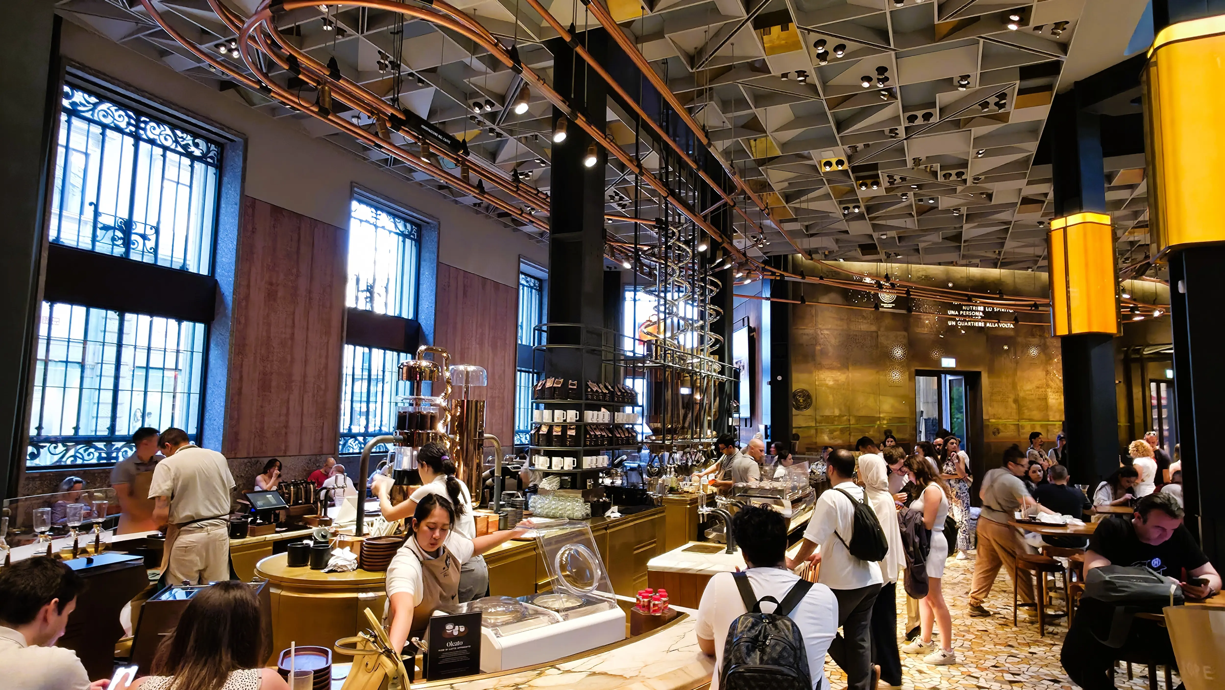 Interior of the Starbucks Reserve Roastery Milano, showcasing marble counters, copper roasting equipment, and artisanal design