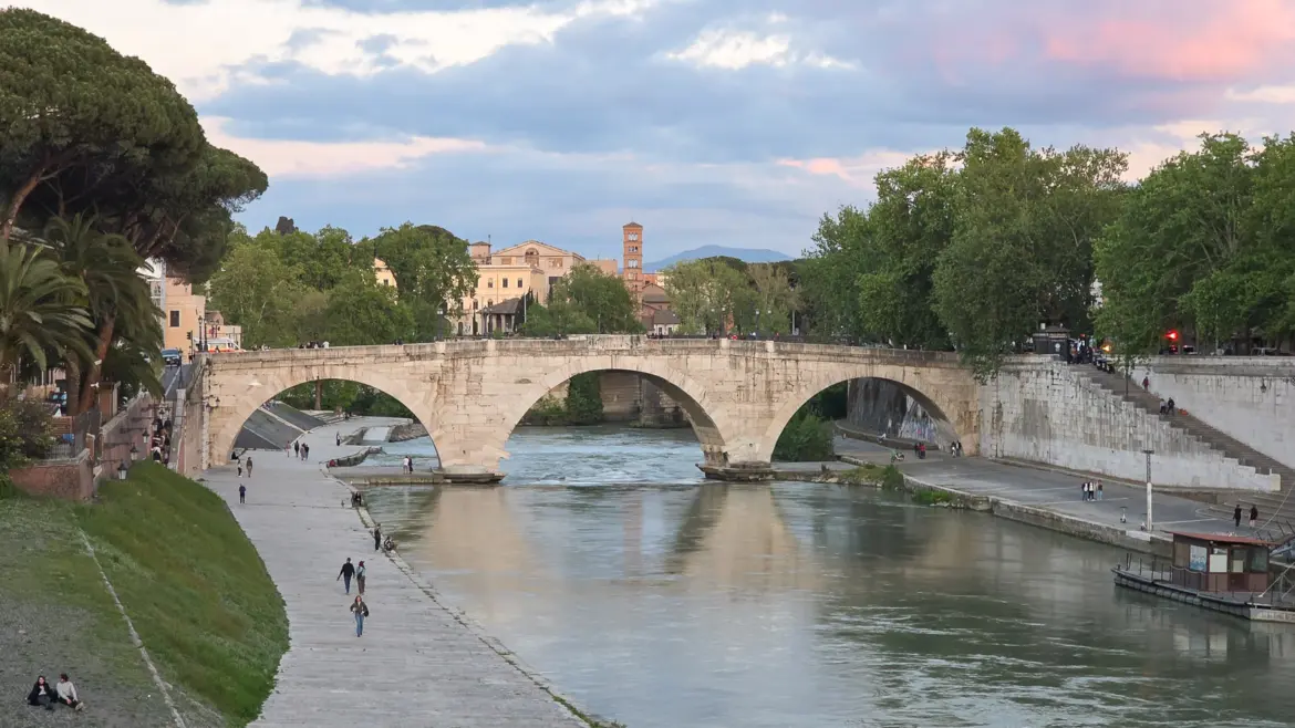 The Tiber River in Rome at evening with bridges reflected in the water and buildings lining both banks