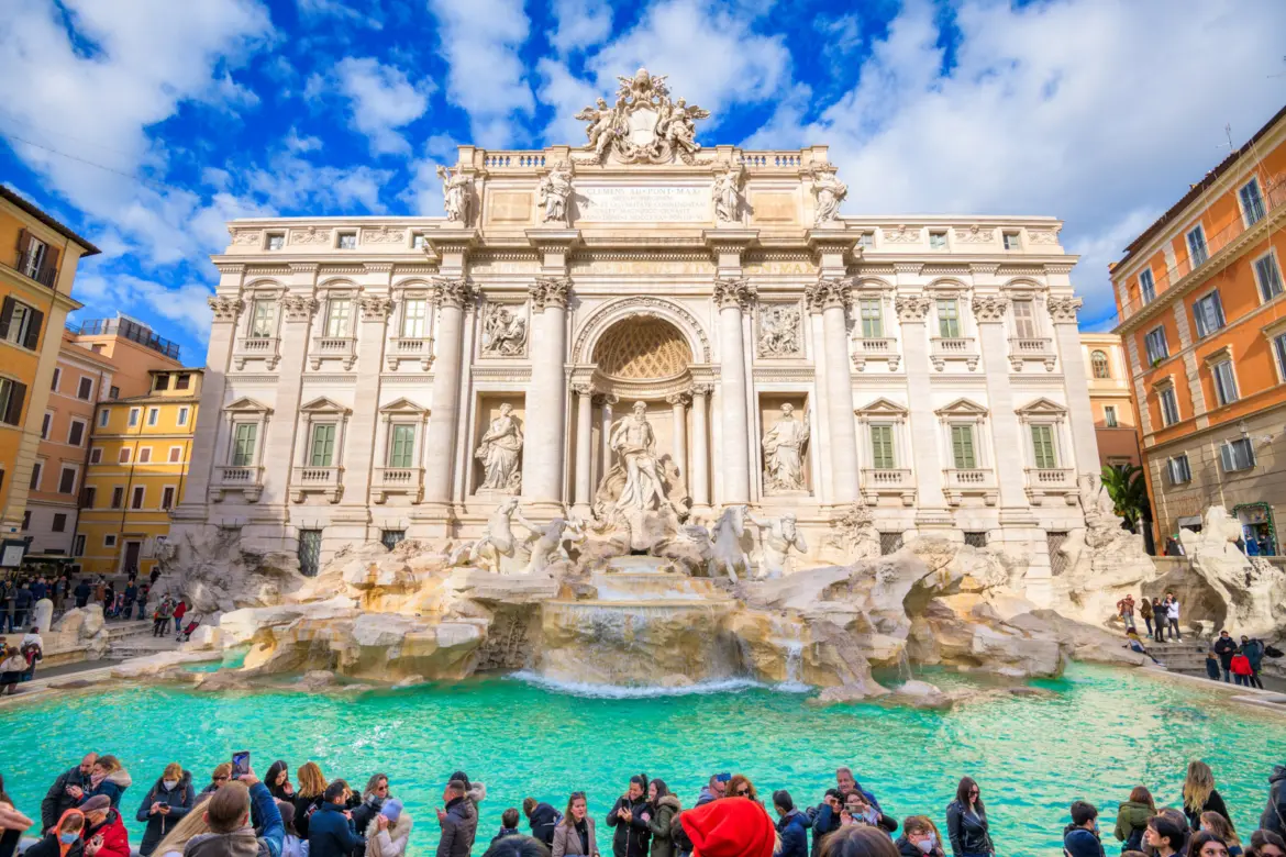 Trevi Fountain in Rome Italy during daytime showing Baroque sculptural details cascading water and visitors gathered at the basin